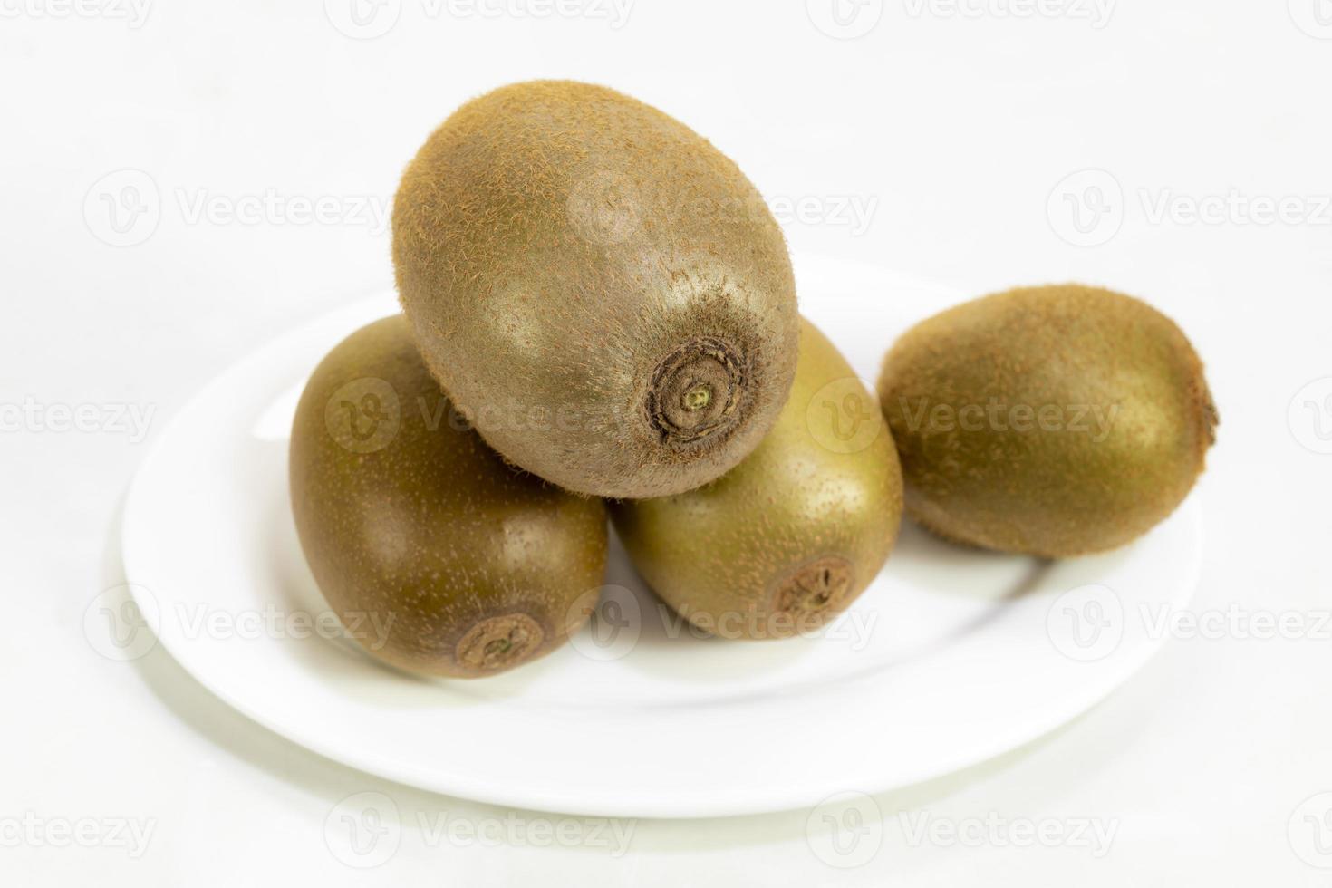 Kiwi fruit in plate isolated on white background photo