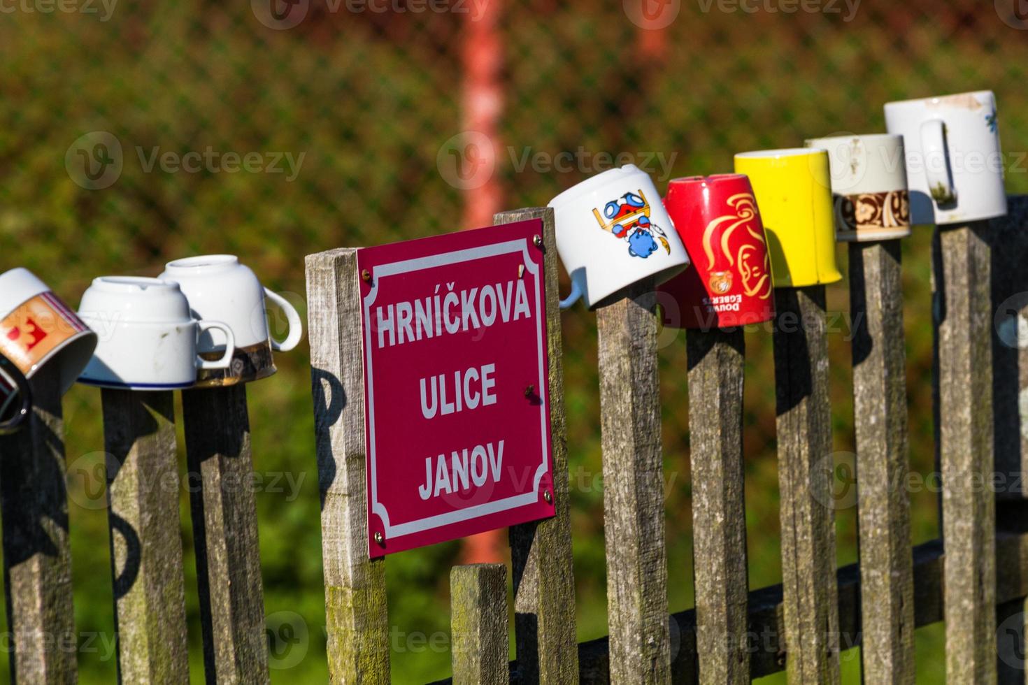 a row of coffee mugs stacked on the fence photo