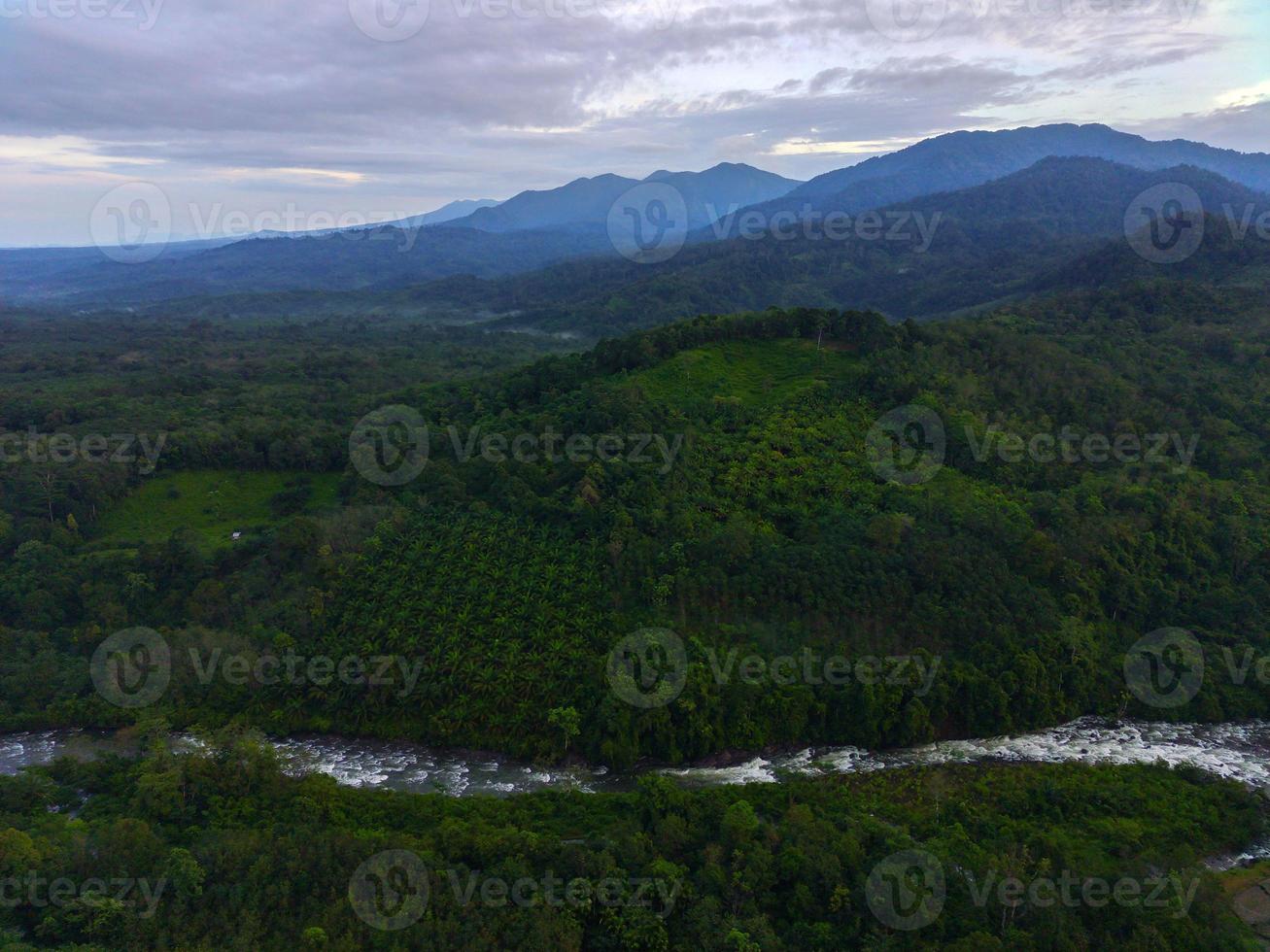 Beautiful morning view of Indonesia. Aerial photo of a river between the mountains and forests of Indonesia