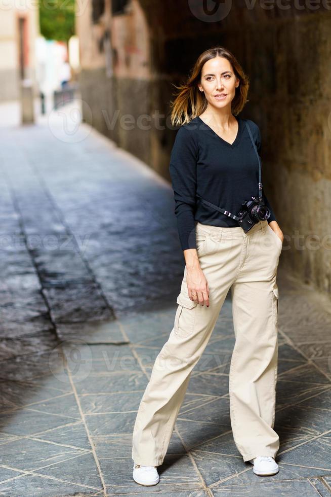 Content female tourist standing in archway during sightseeing trip photo