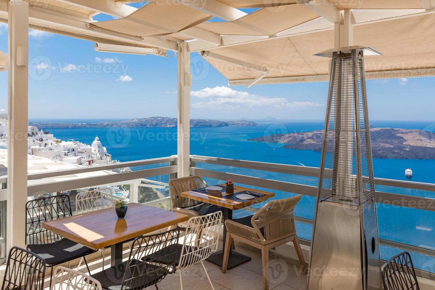 cafetería en la terraza con vistas al mar. isla de santorini, grecia. hermoso destino de viaje, vista de la caldera de un restaurante. vacaciones de lujo, idílicas vacaciones de verano. foto