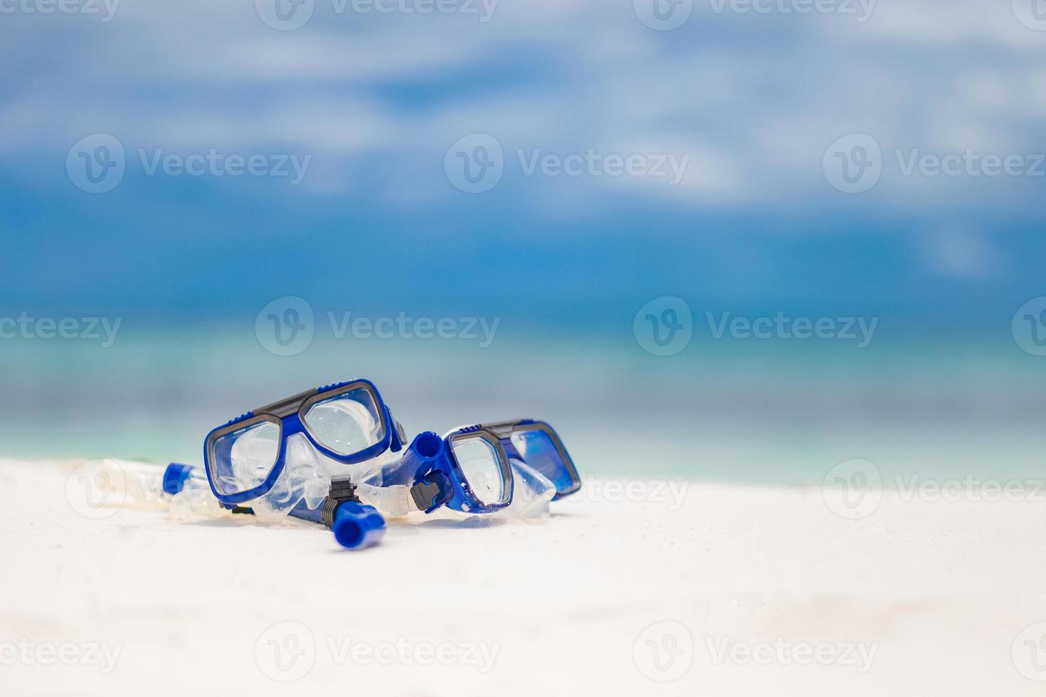 Diving goggles and snorkel gear on sandy beach. Snorkeling water sport and recreational equipment, exotic beach scenery, summer vacation and tourism concept photo