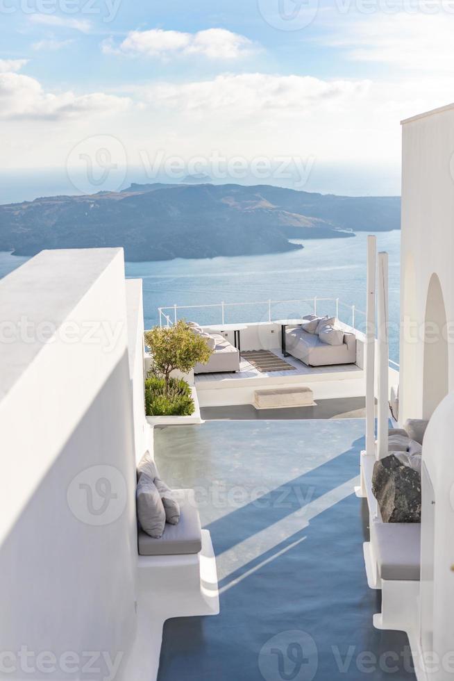 flores en jarrón blanco y vistas al mar desde la caldera. arquitectura blanca en la isla de santorini, grecia. hermoso paisaje, vista al mar. paisaje de viajes de verano, pueblo blanco borroso, concepto de turismo foto