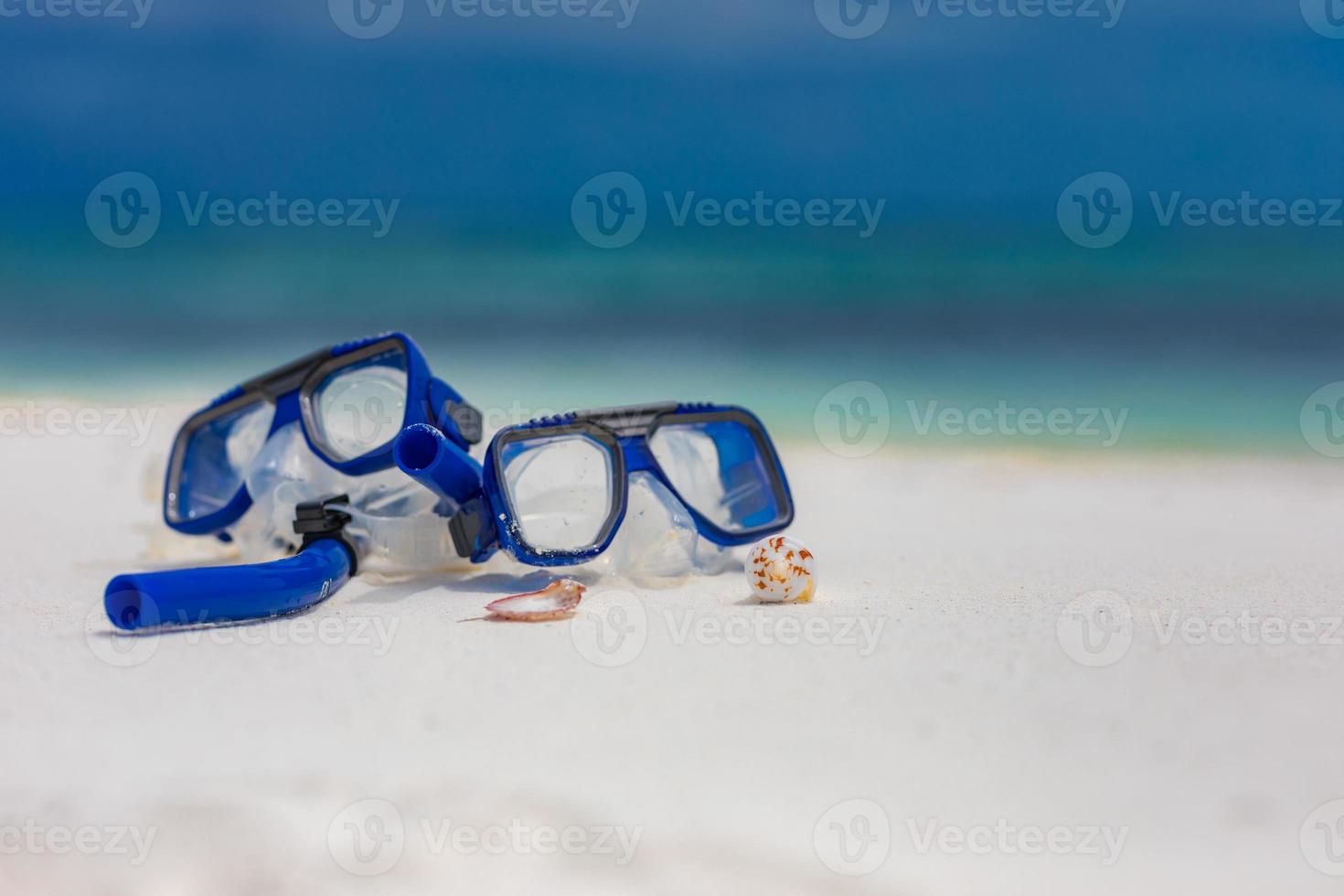 Diving goggles and snorkel gear on sandy beach. Snorkeling water sport and recreational equipment, exotic beach scenery, summer vacation and tourism concept photo