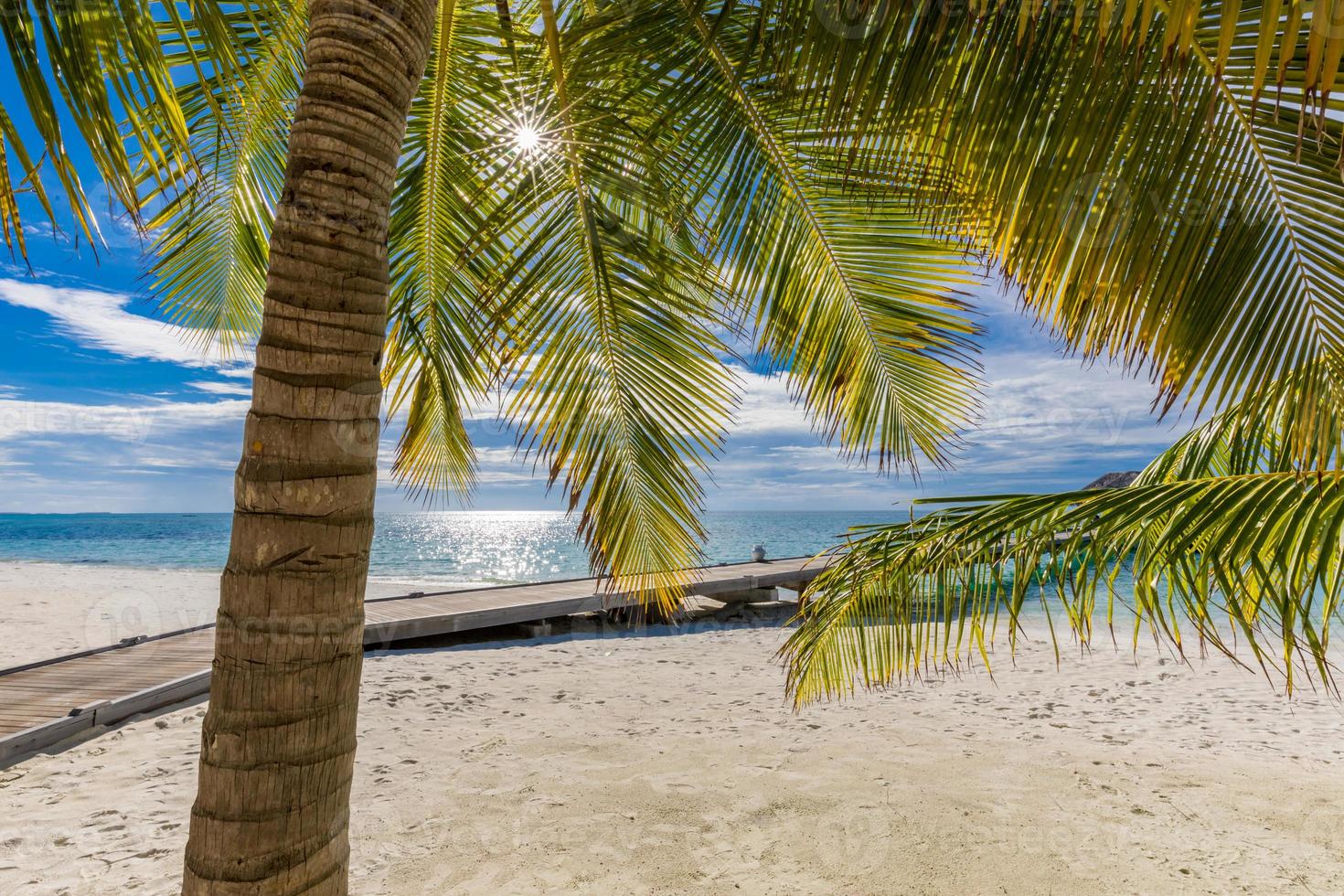 paisaje exótico de maldivas. playa de isla tropical con rayos de sol. idílico y pacífico concepto de cielo de arena de mar inspirador. fondo de playa tropical como paisaje de verano, vacaciones de escena y vacaciones foto