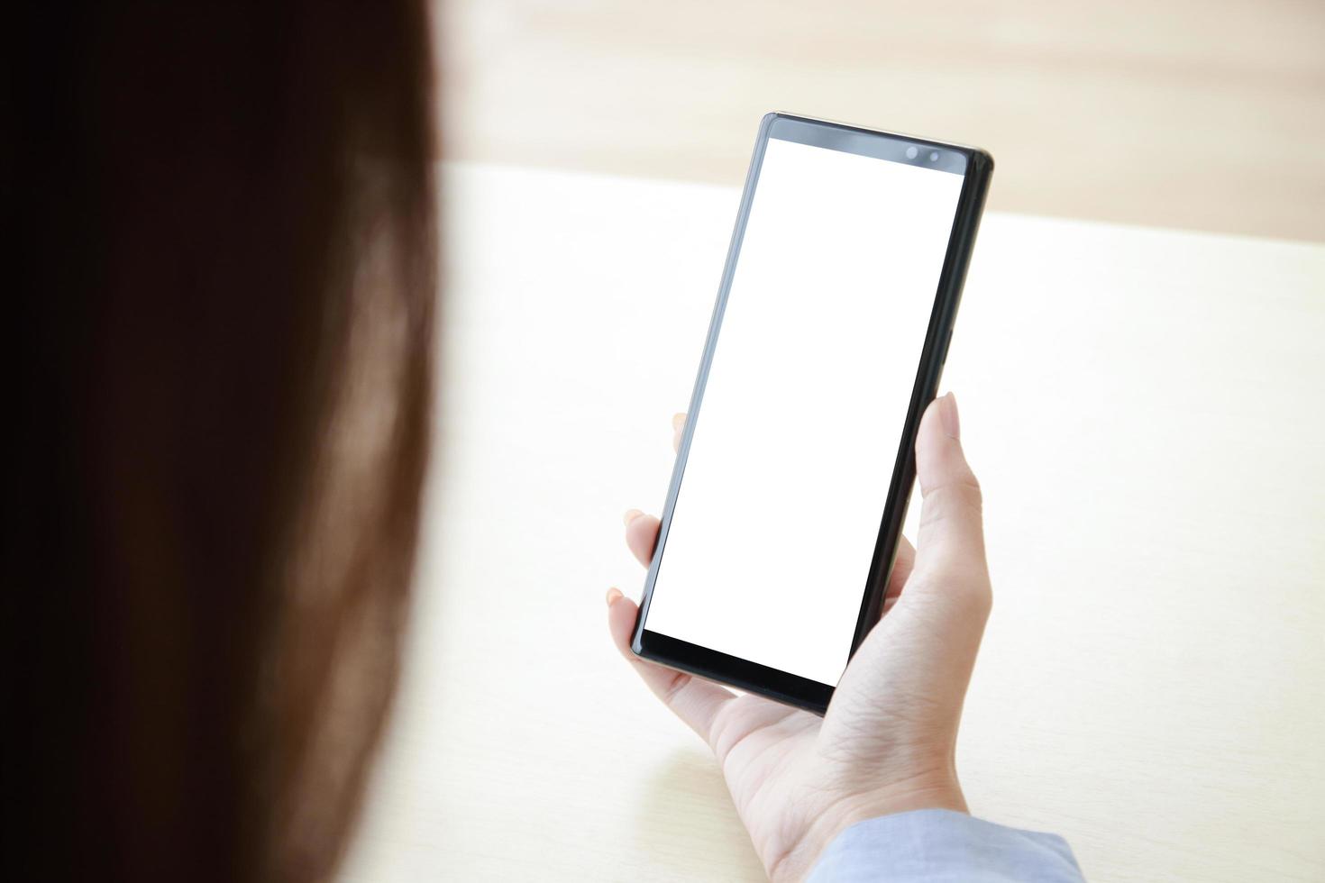 A woman holding a black smartphone with a white screen Connect with online technology communications. Smartphone concept with screen, free space for copying text or information content. Clipping Path photo