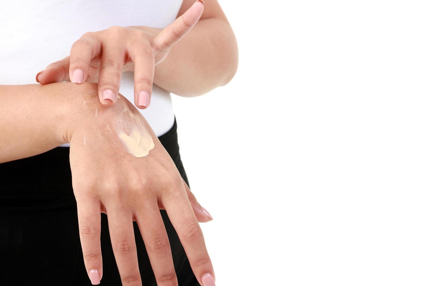las mujeres jóvenes aplican crema nutritiva en la piel del dorso de la mano para que esté húmeda, no seca. concepto de belleza y cuidado de la salud foto