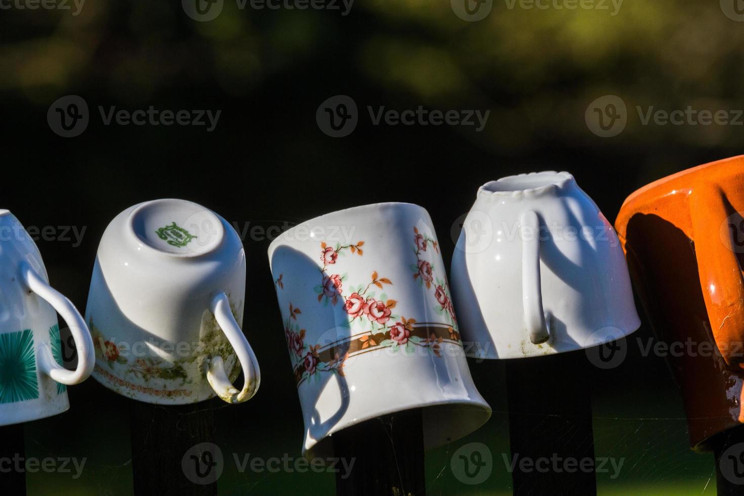 una fila de tazas de café apiladas en la cerca foto