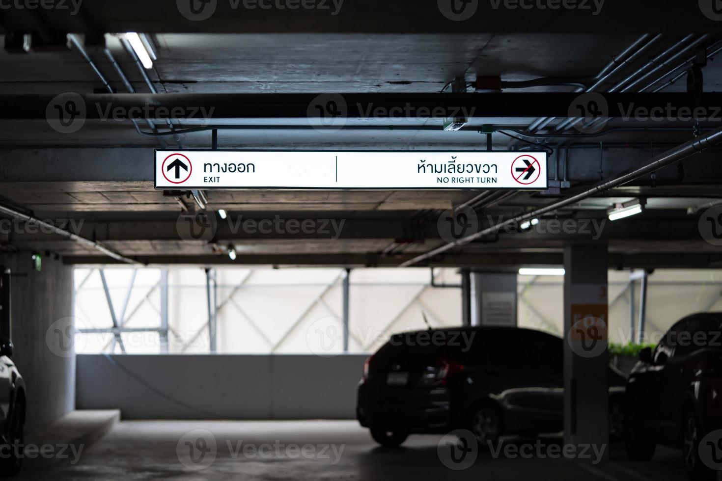 Carparking Lighting box is hung on ceiling. Thai Laungae letter on lighting box at the left side mean EXIT and right side mean No RIGHT TURN photo