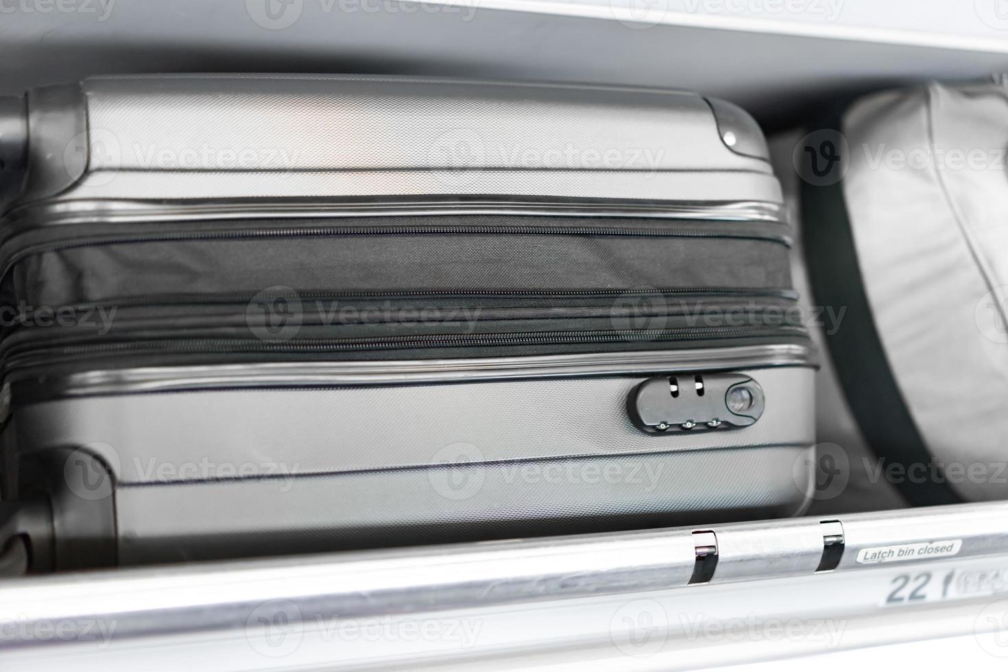 luggage on the top airplane shelf overhead passenger seat photo