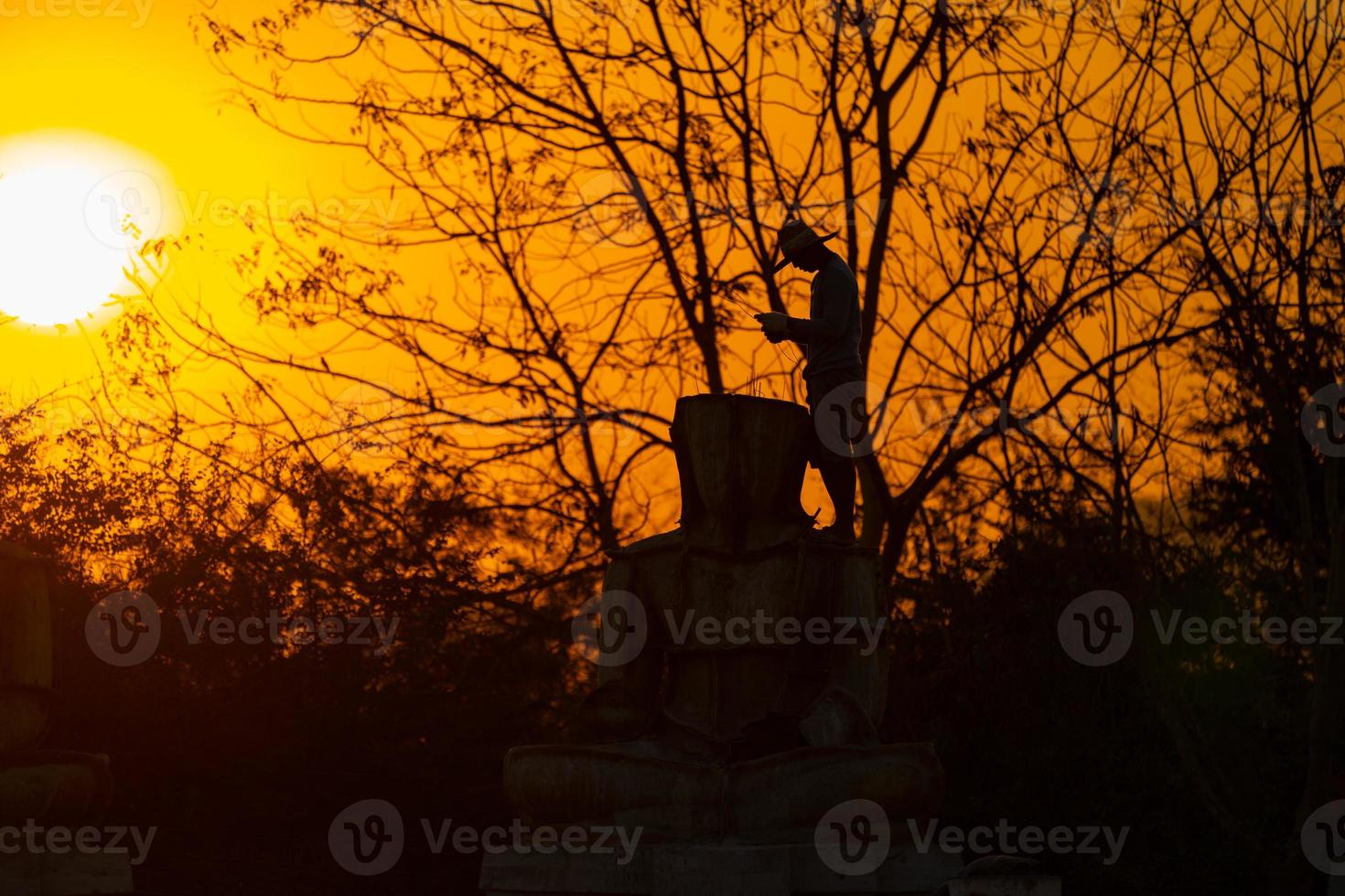 Silhouette Buddha statue and Asian worker, he is working and casting Buddha statue at twilight sunset background. Thailand. photo
