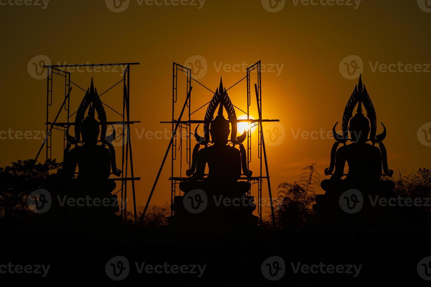 siluetee la estatua de buda entre la creación y el proceso de construcción, en el campo al aire libre con la puesta de sol y el período de crepúsculo, tailandia. foto