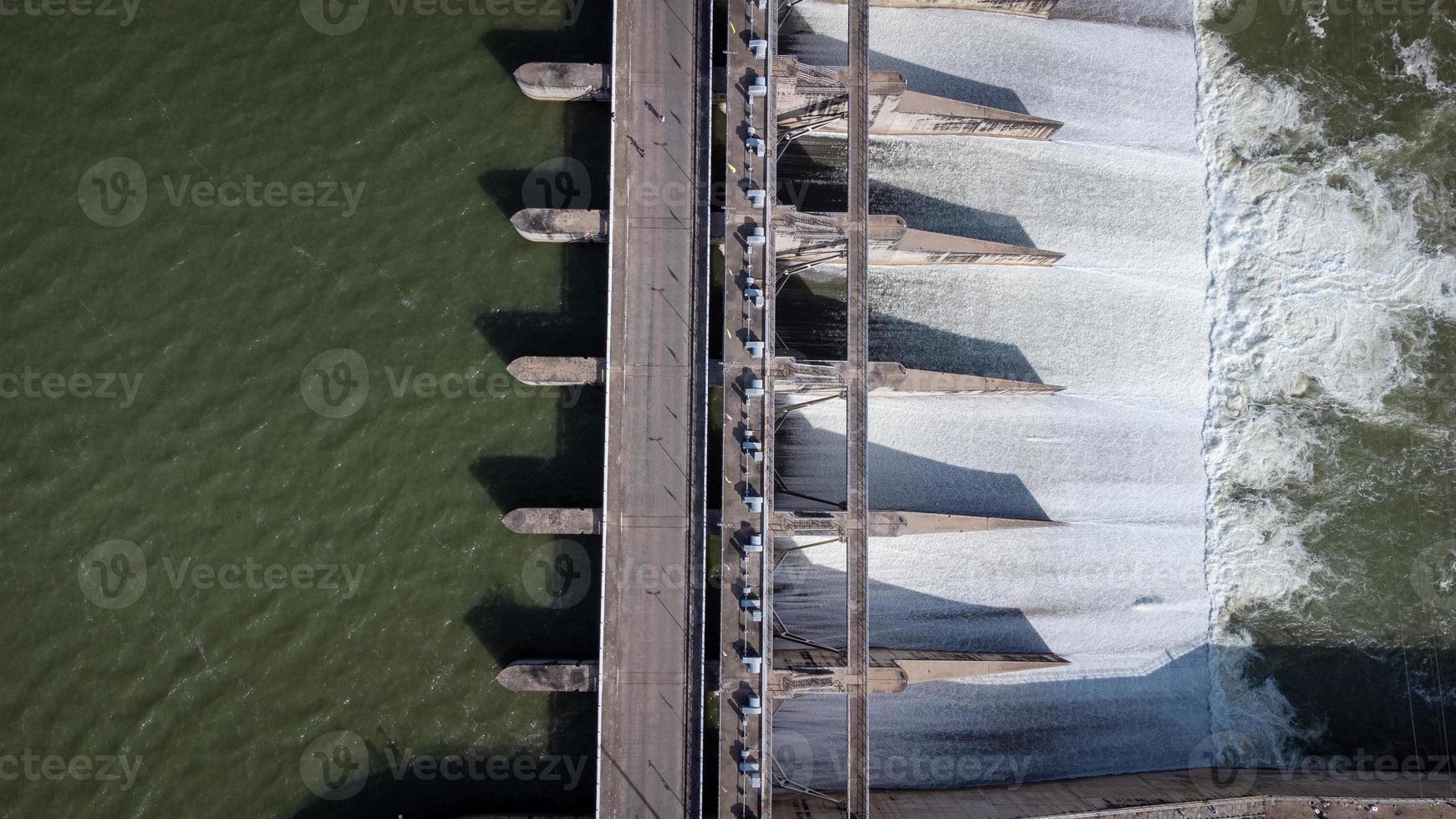 An aerial view over the Pasak Jolasid dam, Lopburi Province, Thailand. Tracking the movement of the floodgates that are releasing water into rural canals in enormous amounts of water. photo