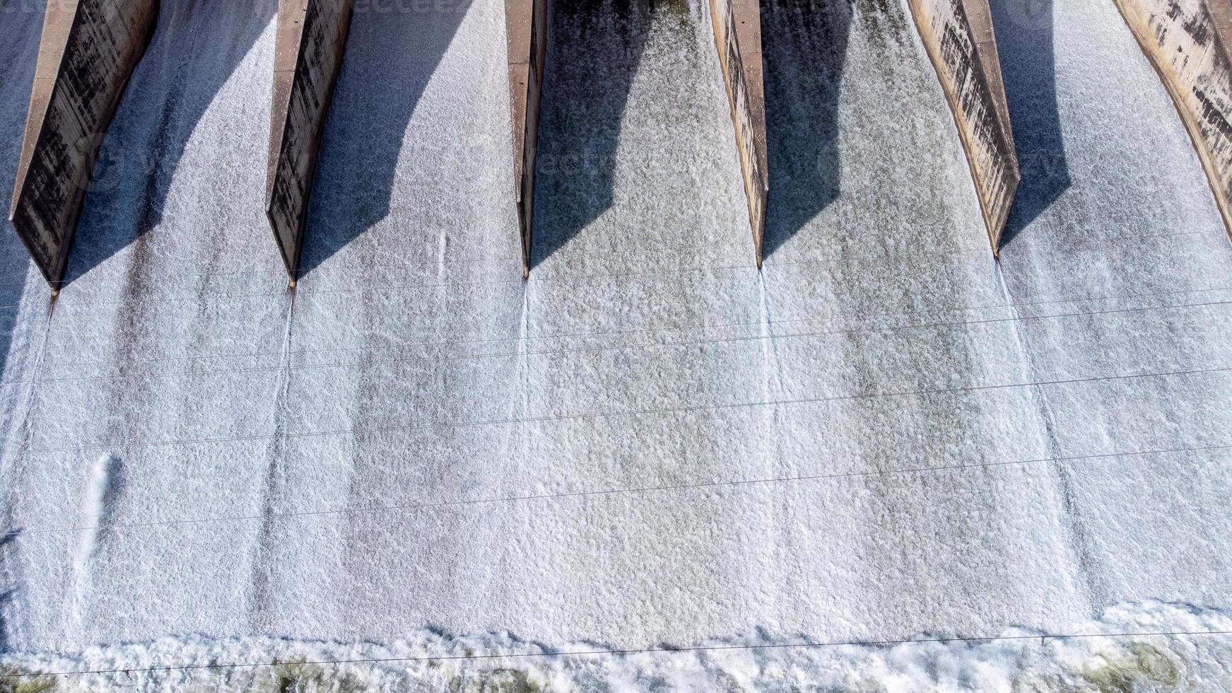 An aerial view over the Pasak Jolasid dam, Lopburi Province, Thailand. Tracking the movement of the floodgates that are releasing water into rural canals in enormous amounts of water. photo