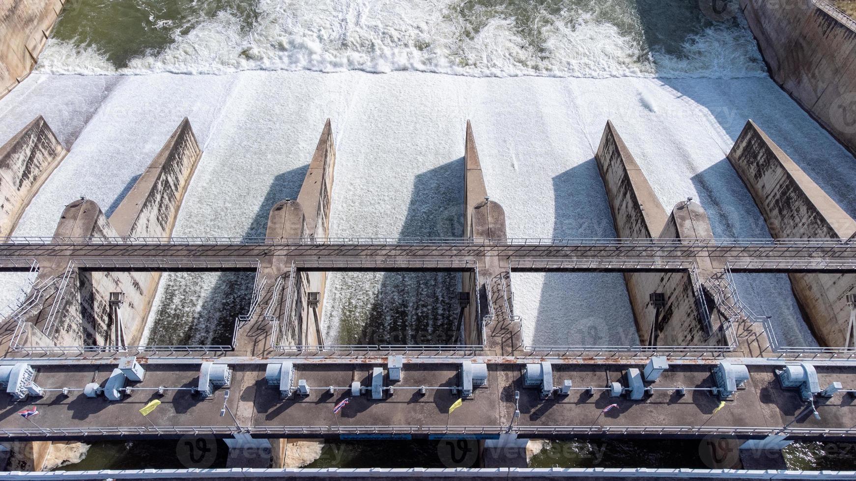 An aerial view over the Pasak Jolasid dam, Lopburi Province, Thailand. Tracking the movement of the floodgates that are releasing water into rural canals in enormous amounts of water. photo