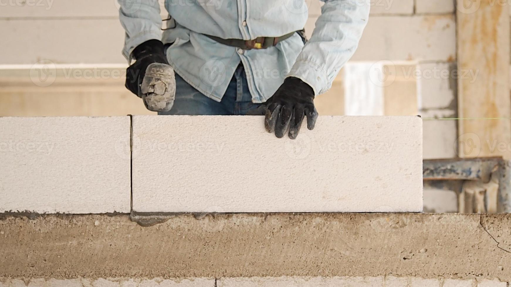 Construction workers are making white lightweight concrete blocks that are better than cement bricks, popular in the construction of homes and public buildings. photo