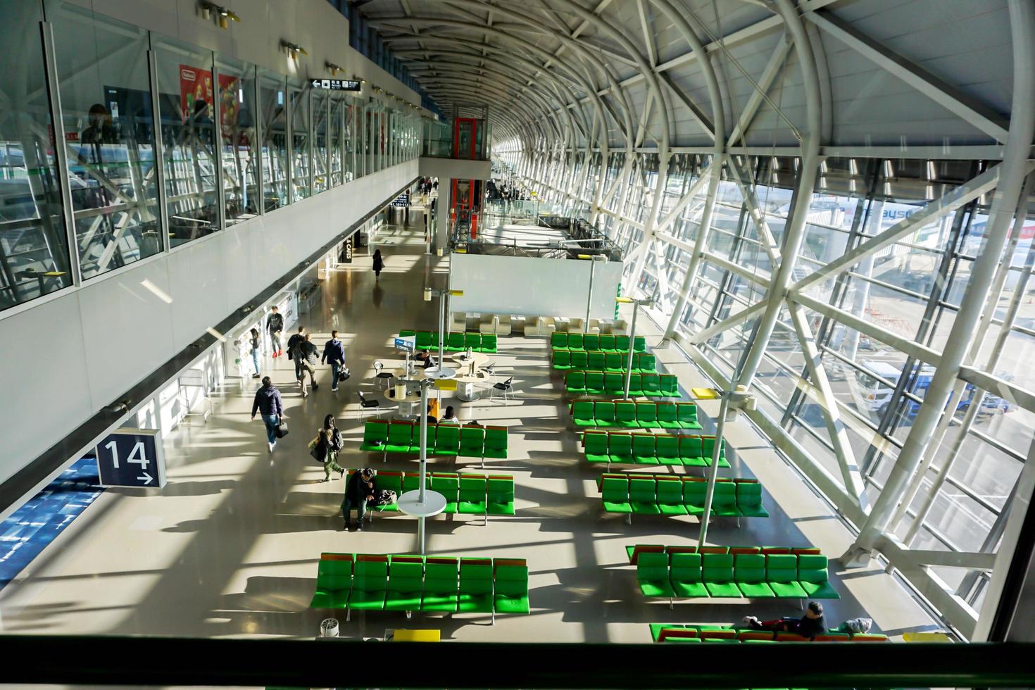 osaka, japón, 2019 - vista del segundo piso de la sala de espera para el avión con turistas y banco verde en la terminal nacional, aeropuerto internacional de kansai. foto