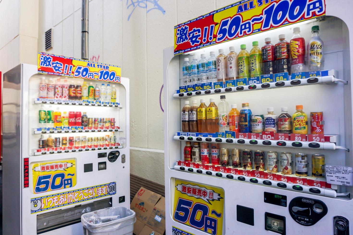 osaka, japón, 2019: la competencia en el negocio de venta de bebidas de máquinas expendedoras comenzó a aumentar en japón. por lo que a menudo vemos bebidas a precio rebajado en un típico callejón de la ciudad foto