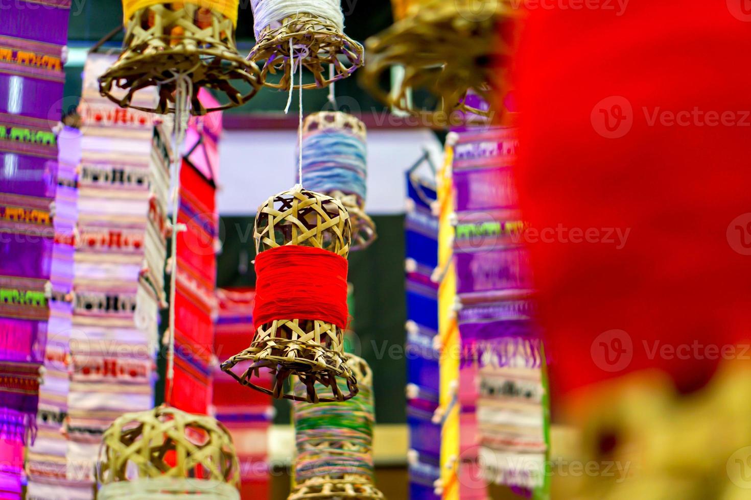 Closeup decorative wicker lantern and Lanna fabric long flags hang on hotel lobby ceiling and blurry background. photo