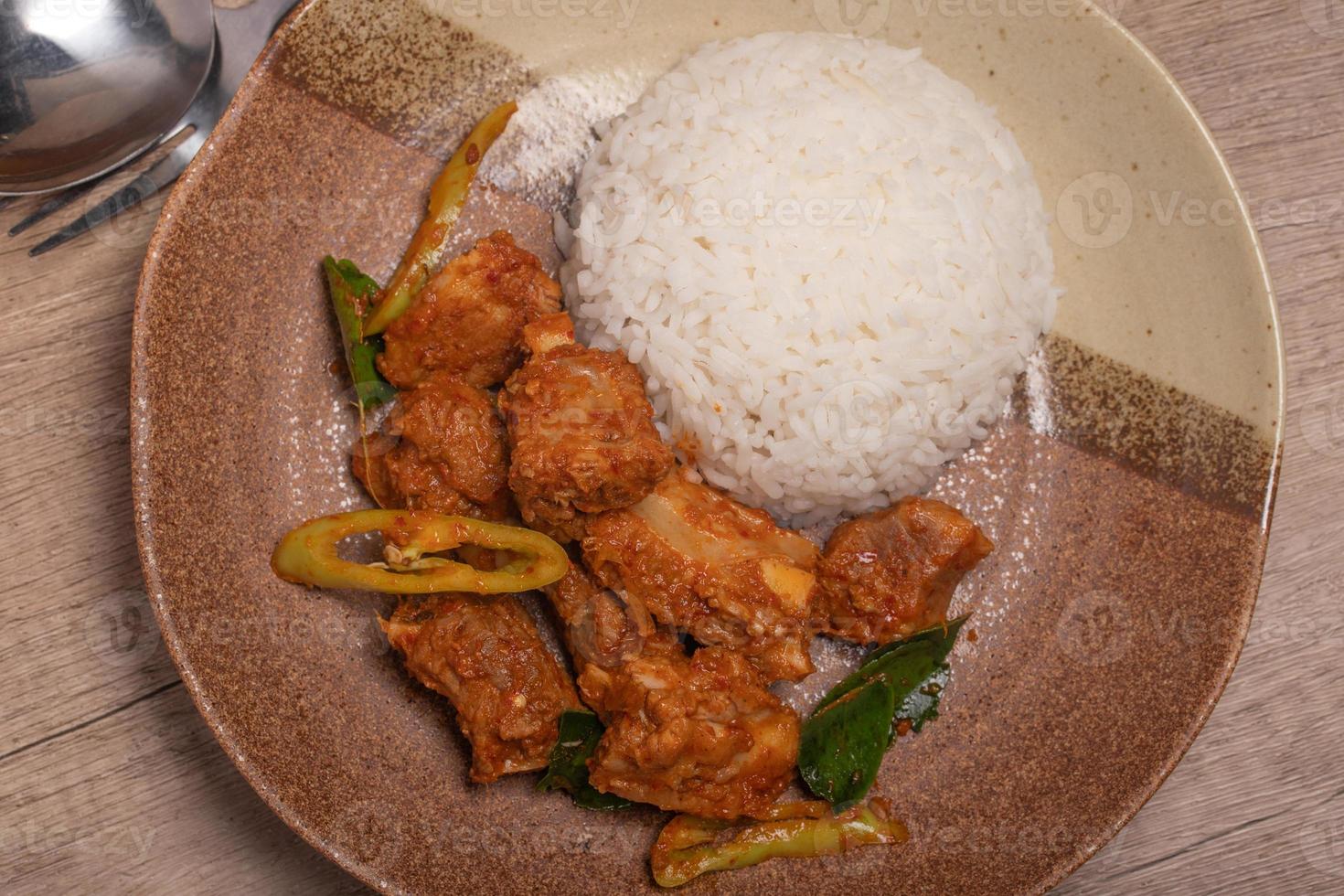 Stir-fried pork ribs with curry paste and steamed rice photo