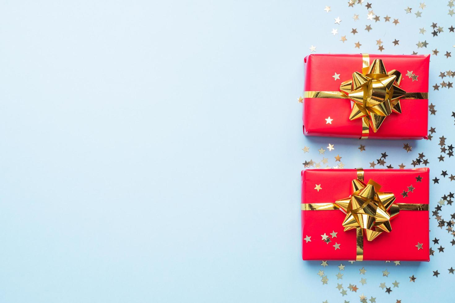 Valentine day composition, Greeting gift box with gold confetti on blue background. Flat lay. photo