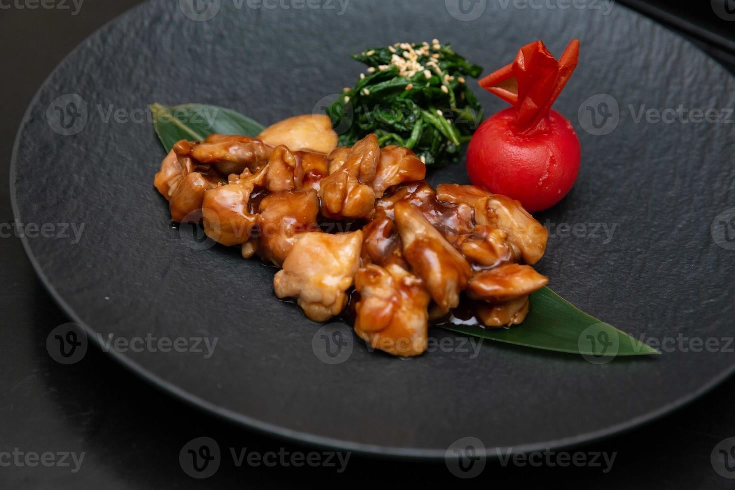 Kung Pao Chicken or Gong Bao Ji Ding at dark slate background. Sichuan Kung Pao is chinese cuisine dish with chicken meat, chilli peppers, peanuts, sauces and onion. photo