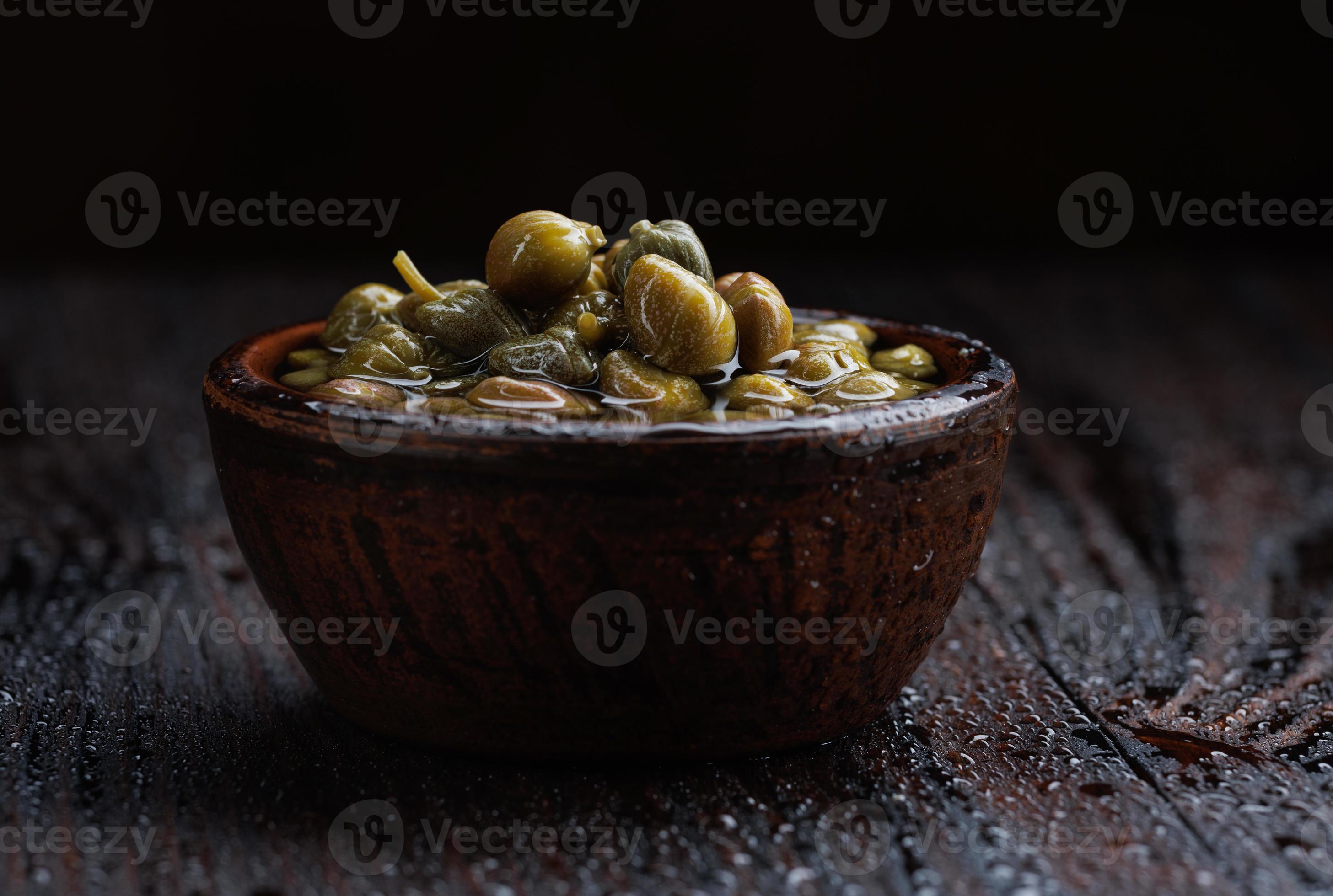 Pickled capers in brine. Clay cup full of capers. 17153320 Stock Photo