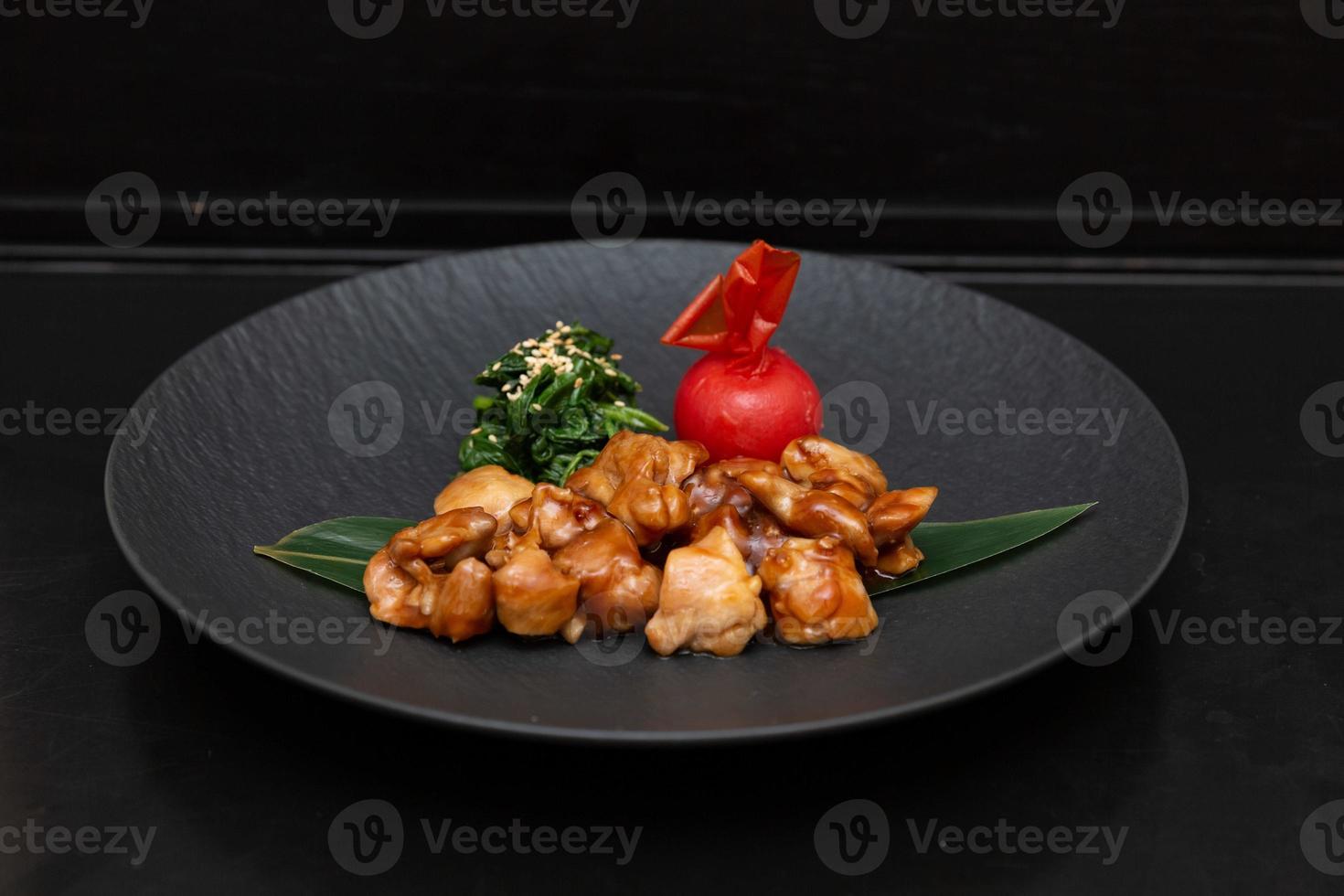 Kung Pao Chicken or Gong Bao Ji Ding at dark slate background. Sichuan Kung Pao is chinese cuisine dish with chicken meat, chilli peppers, peanuts, sauces and onion. photo