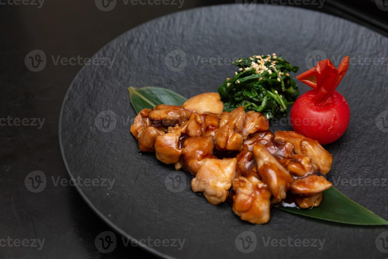 Kung Pao Chicken or Gong Bao Ji Ding at dark slate background. Sichuan Kung Pao is chinese cuisine dish with chicken meat, chilli peppers, peanuts, sauces and onion. photo