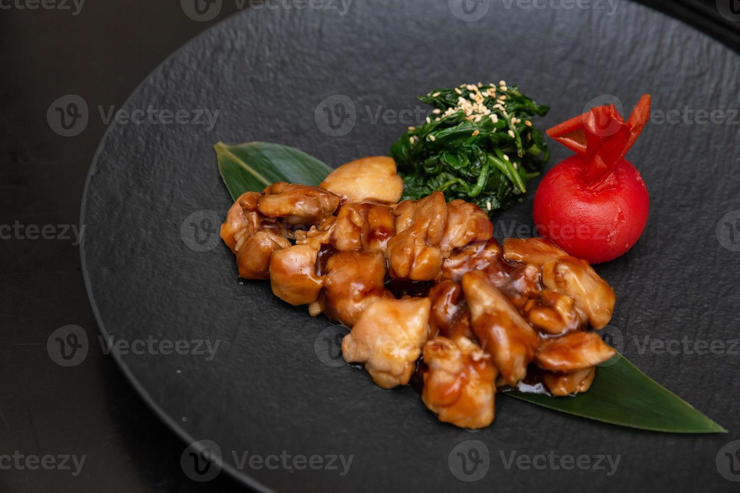 Kung Pao Chicken or Gong Bao Ji Ding at dark slate background. Sichuan Kung Pao is chinese cuisine dish with chicken meat, chilli peppers, peanuts, sauces and onion. photo