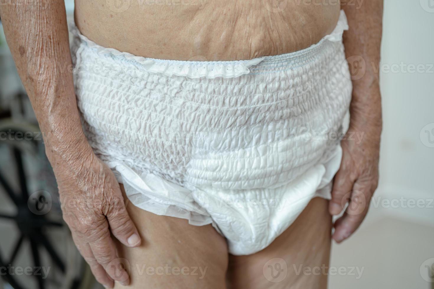 Paciente asiático mayor o mayor de la mujer de la señora mayor que lleva el pañal de la incontinencia en la sala del hospital de enfermería, concepto médico fuerte sano. foto