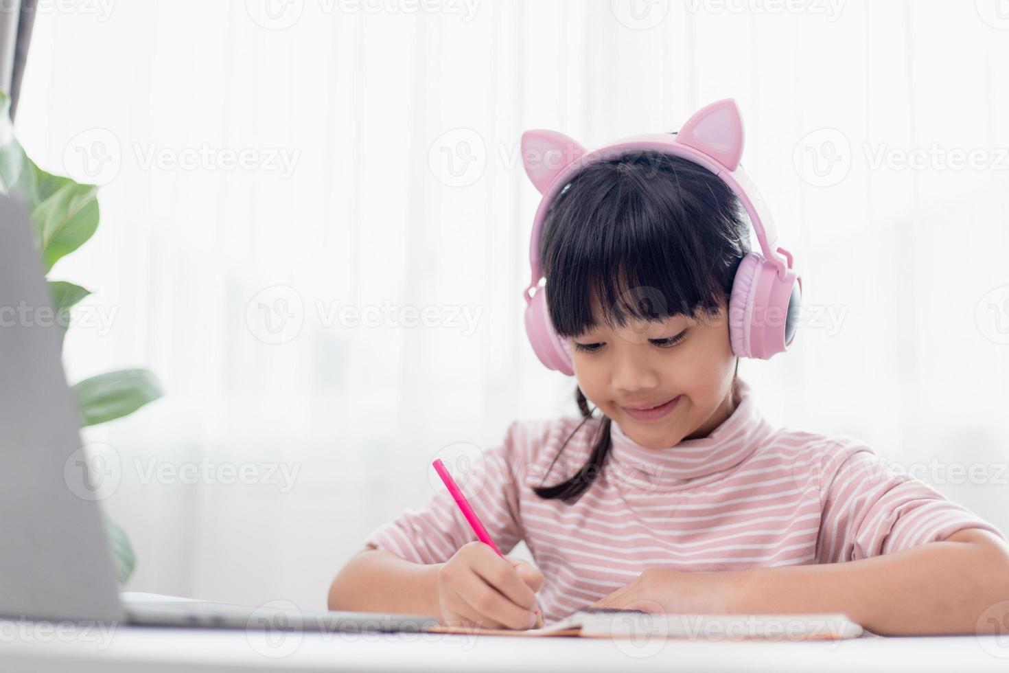 Asian little girl in headphones have video call distant class with teacher using laptop, study online on computer, homeschooling concept photo
