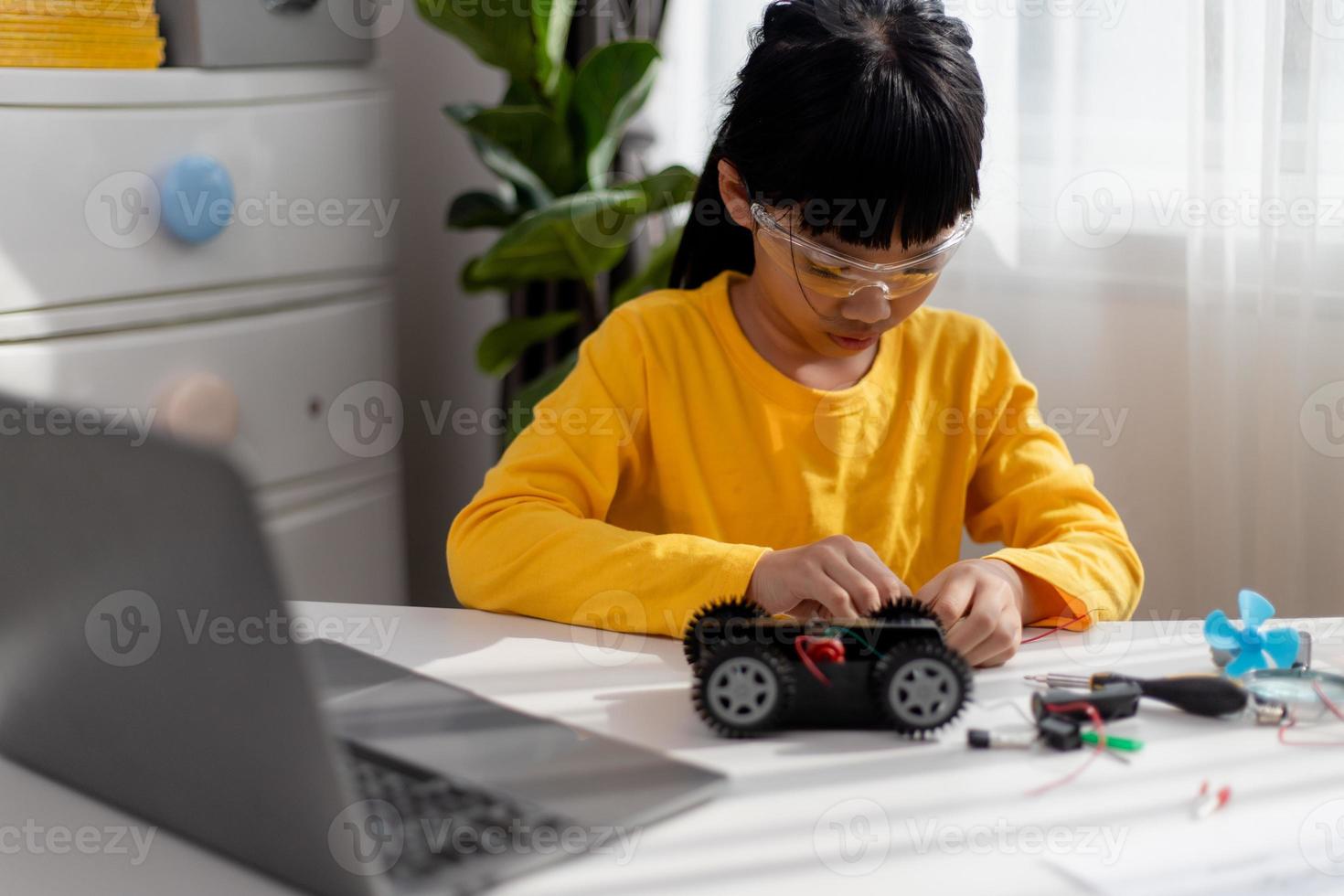 los estudiantes de asia aprenden en casa a codificar autos robot y cables de tableros electrónicos en tallo, vapor, ingeniería matemática, ciencia, tecnología, código de computadora en robótica para el concepto de niños. foto