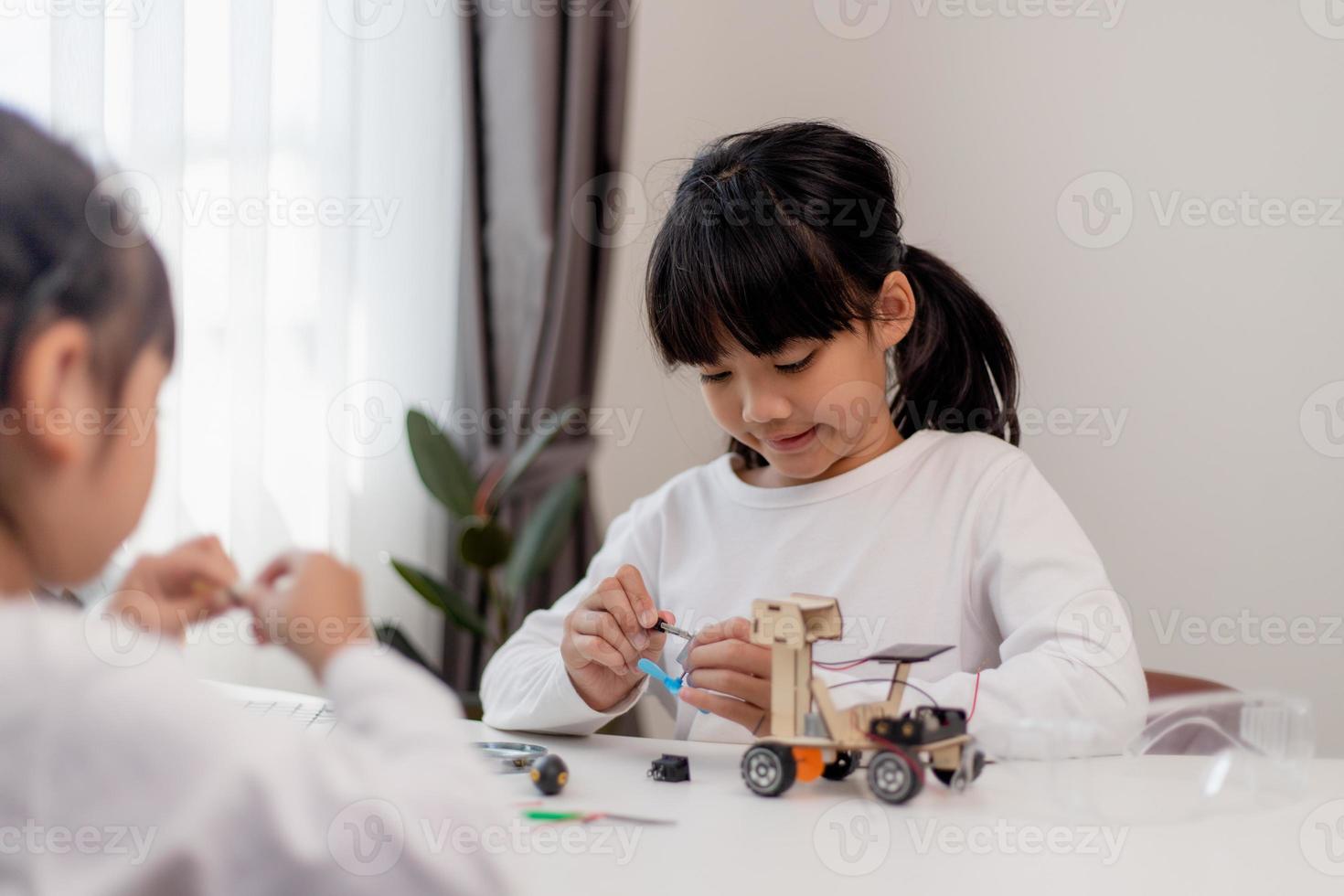 los estudiantes de asia aprenden en casa a codificar autos robot y cables de tableros electrónicos en tallo, vapor, ingeniería matemática, ciencia, tecnología, código de computadora en robótica para el concepto de niños. foto