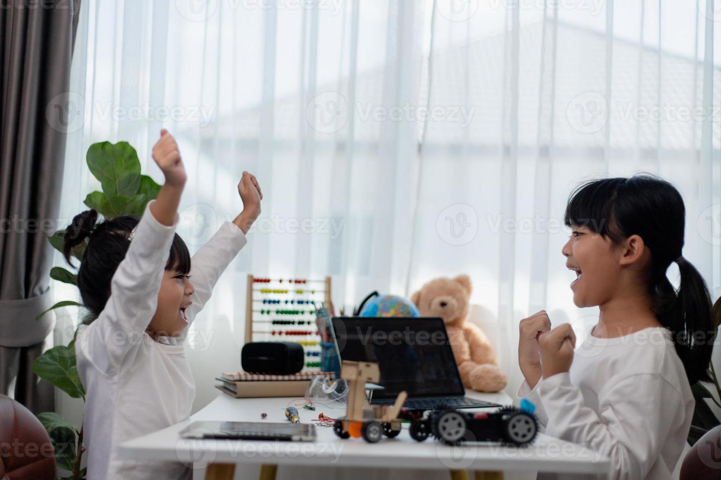 Asia students learn at home in coding robot cars and electronic board cables in STEM, STEAM, mathematics engineering science technology computer code in robotics for kids concept. photo