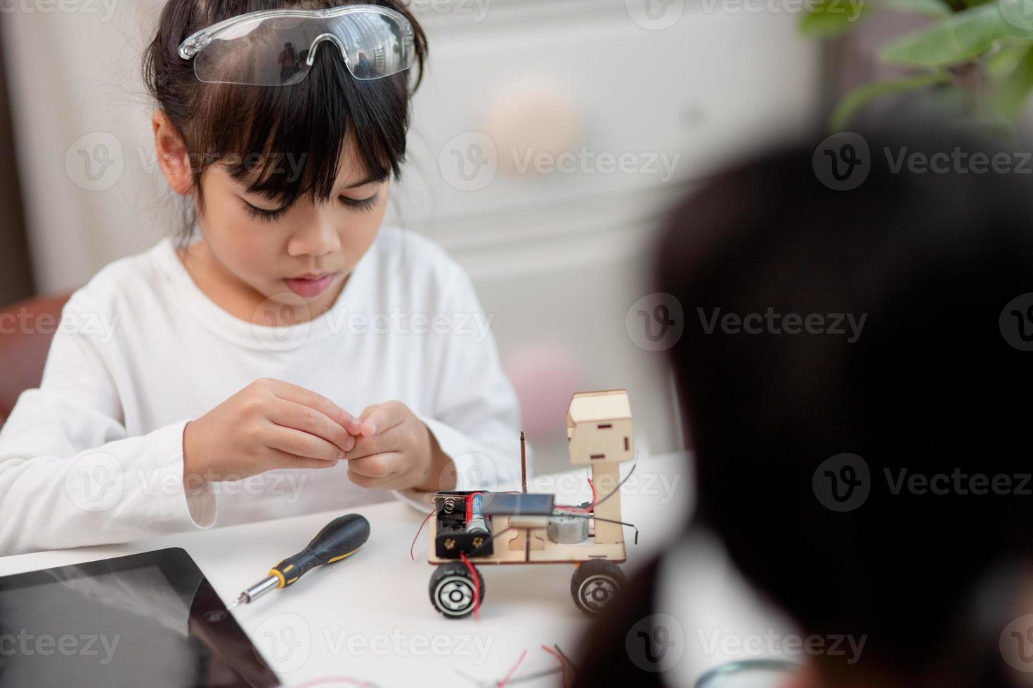 los estudiantes de asia aprenden en casa a codificar autos robot y cables de tableros electrónicos en tallo, vapor, ingeniería matemática, ciencia, tecnología, código de computadora en robótica para el concepto de niños. foto