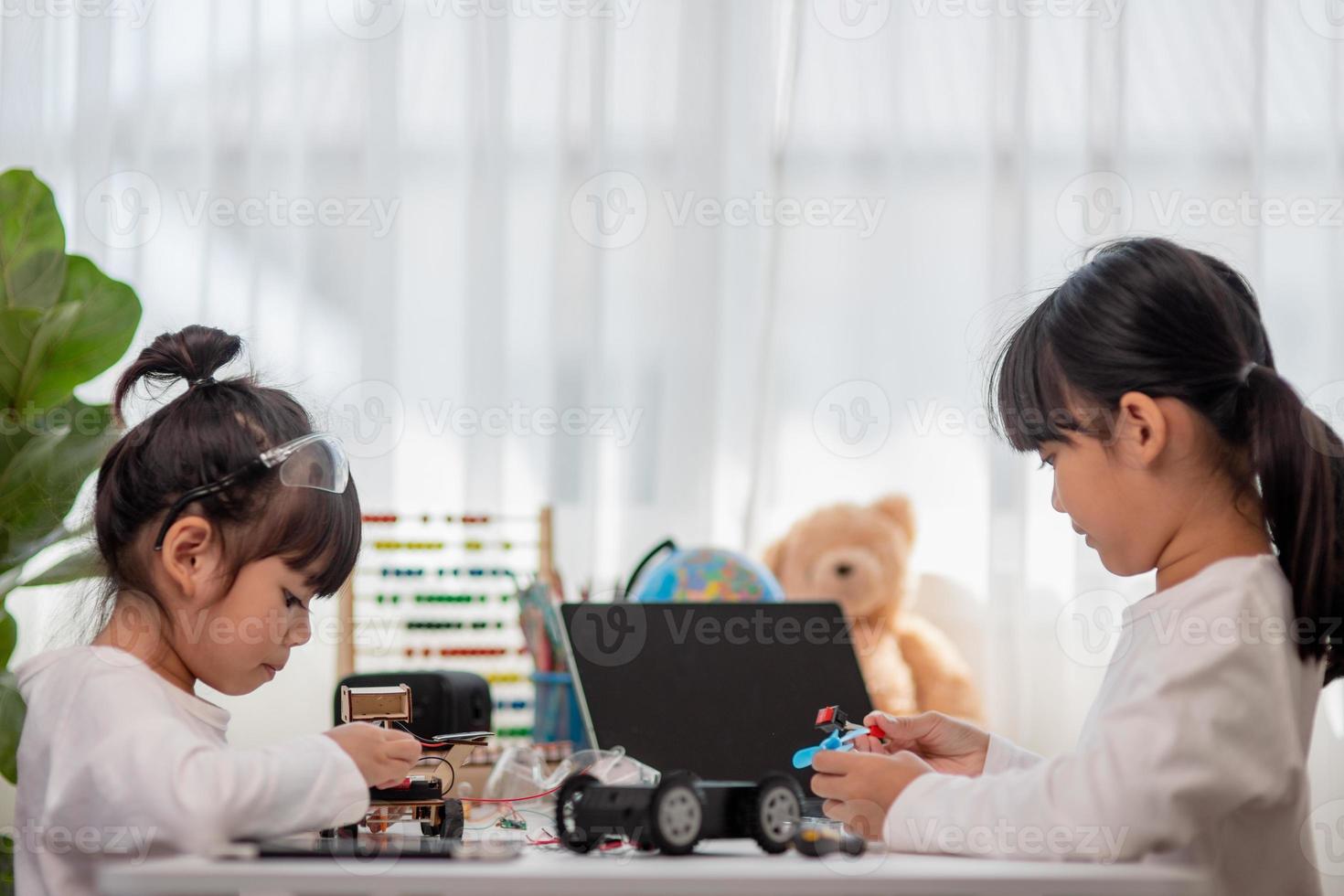 Asia students learn at home in coding robot cars and electronic board cables in STEM, STEAM, mathematics engineering science technology computer code in robotics for kids concept. photo