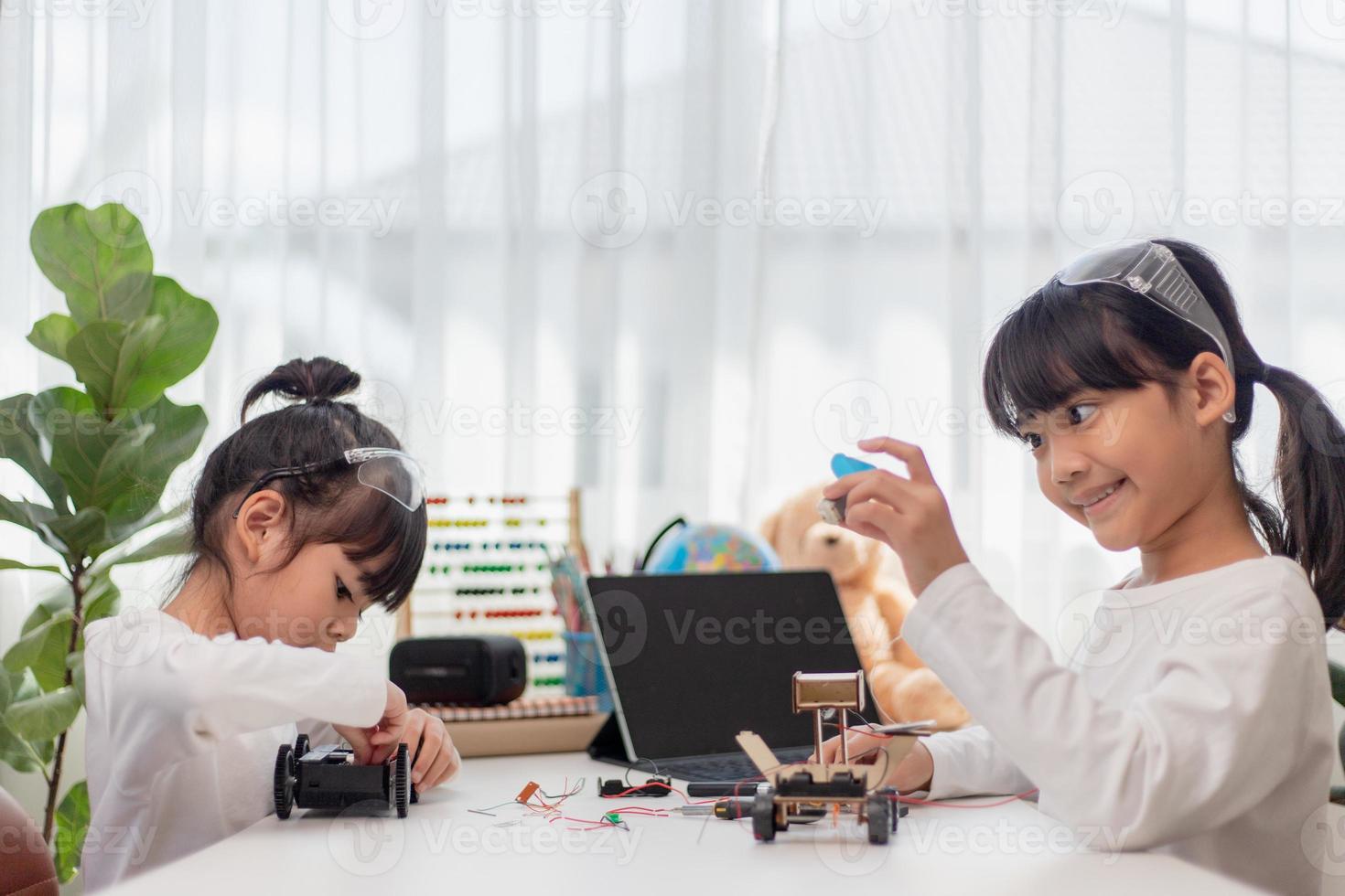 Asia students learn at home in coding robot cars and electronic board cables in STEM, STEAM, mathematics engineering science technology computer code in robotics for kids concept. photo