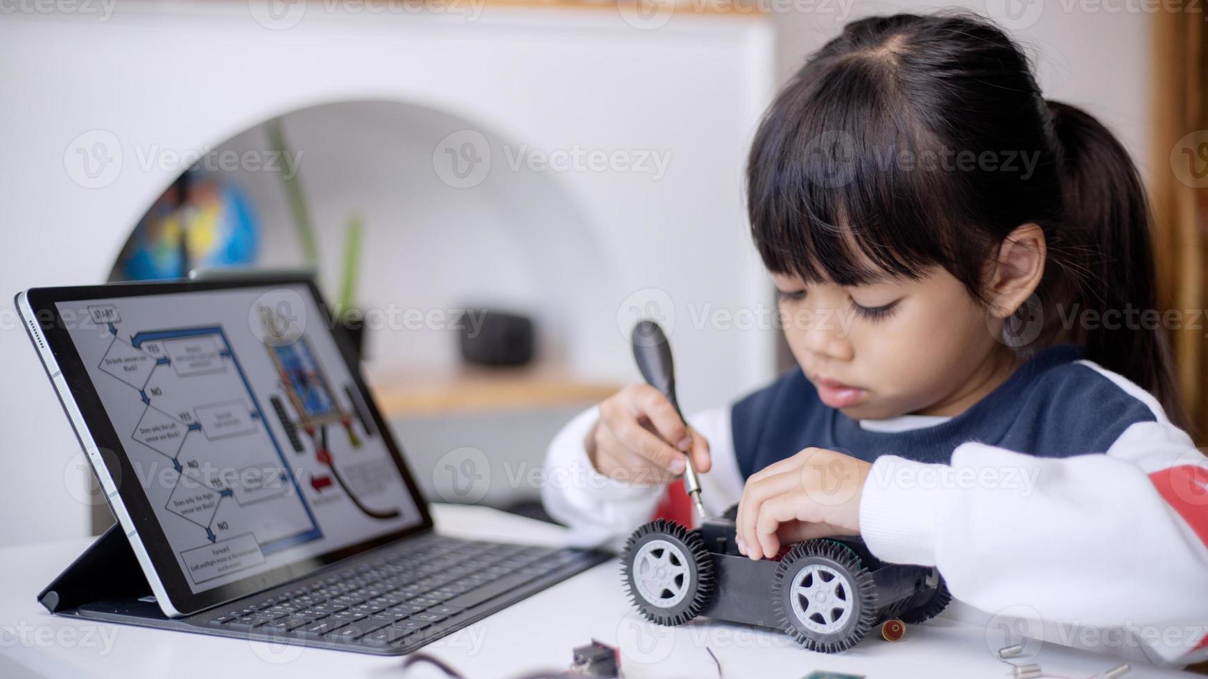 los estudiantes de asia aprenden en casa a codificar autos robot y cables de tableros electrónicos en tallo, vapor, ingeniería matemática, ciencia, tecnología, código de computadora en robótica para el concepto de niños foto