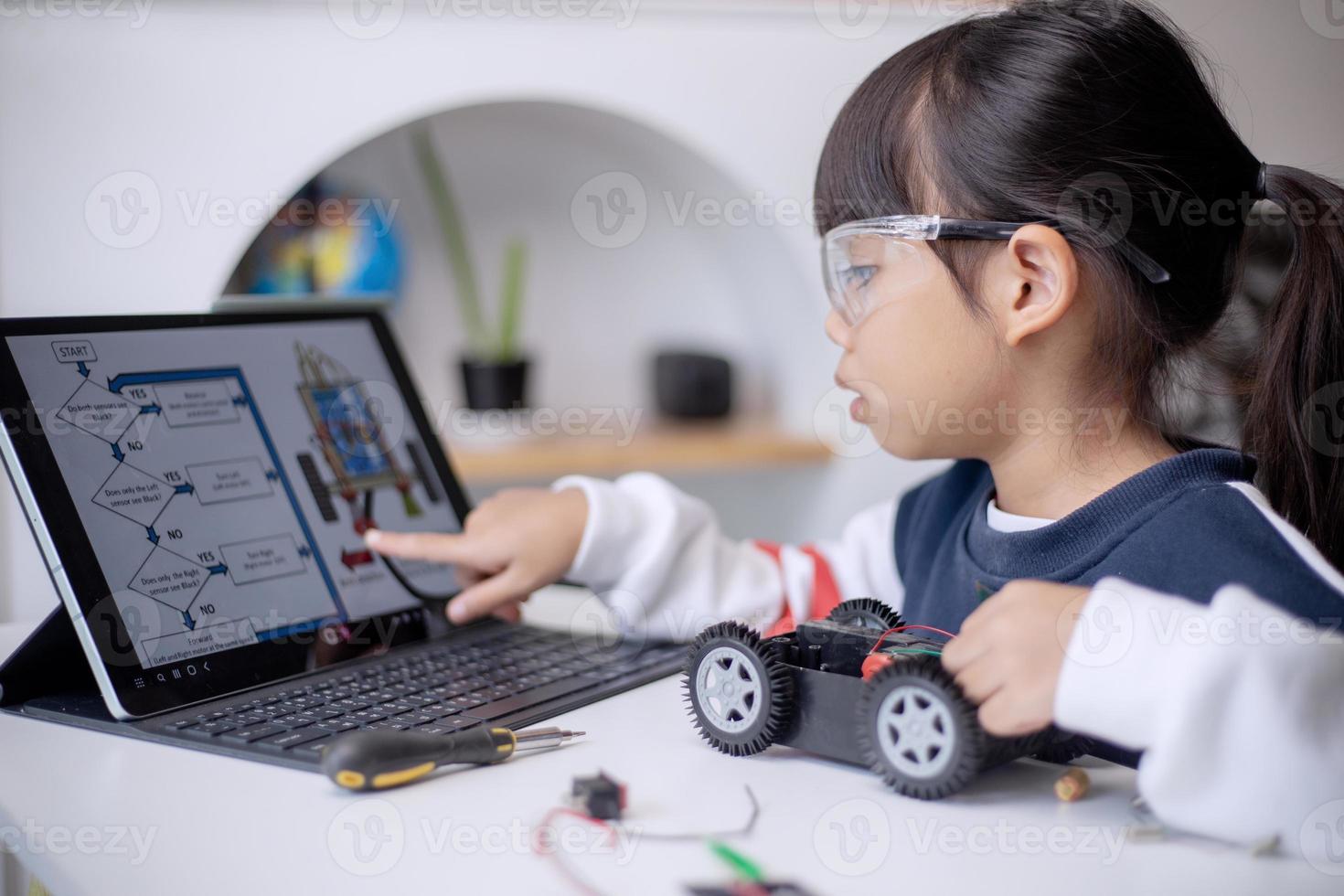 los estudiantes de asia aprenden en casa a codificar autos robot y cables de tableros electrónicos en tallo, vapor, ingeniería matemática, ciencia, tecnología, código de computadora en robótica para el concepto de niños foto