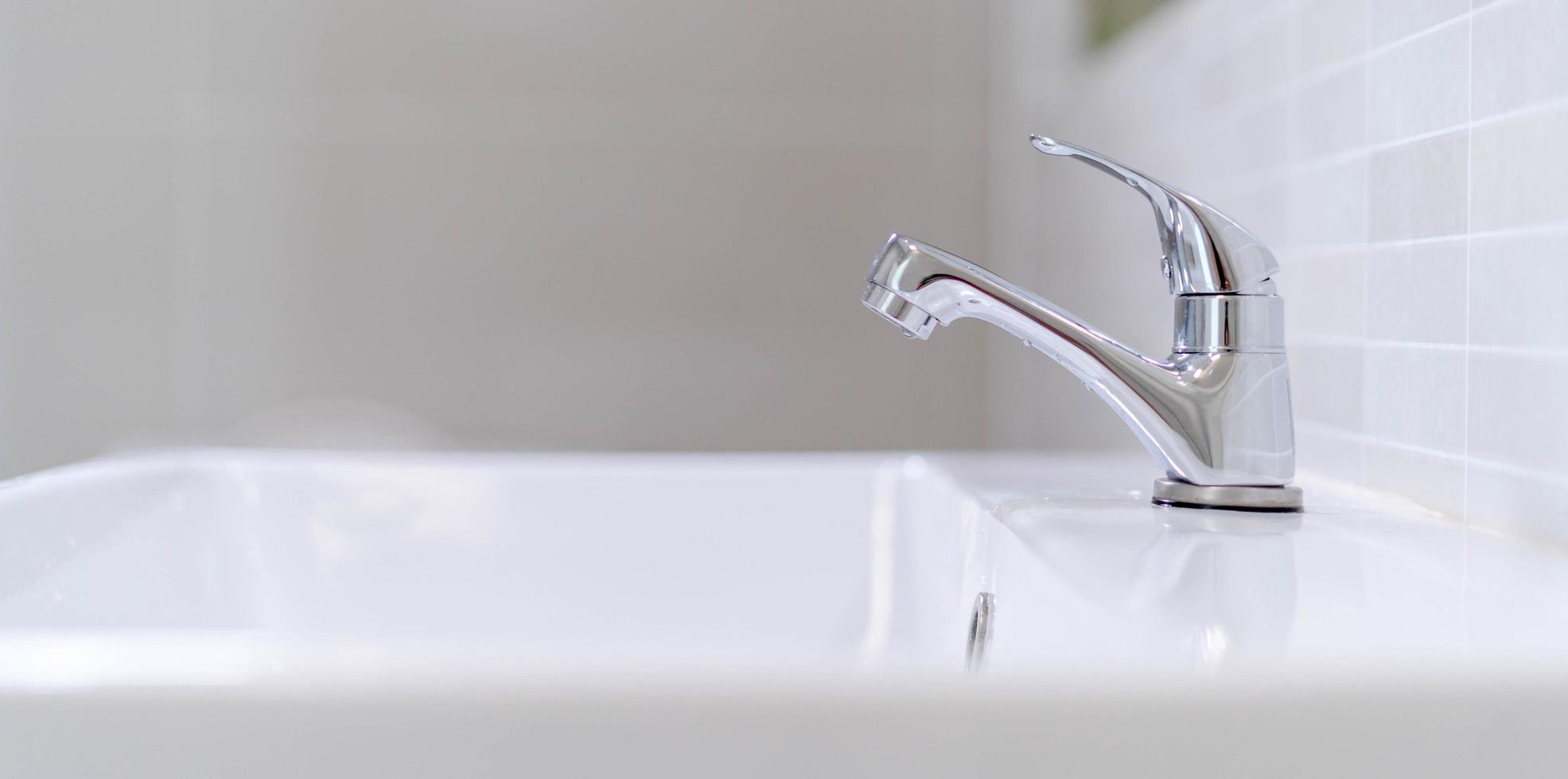 The bathroom faucet is turned off to save water energy and protect the environment. water saving concept photo