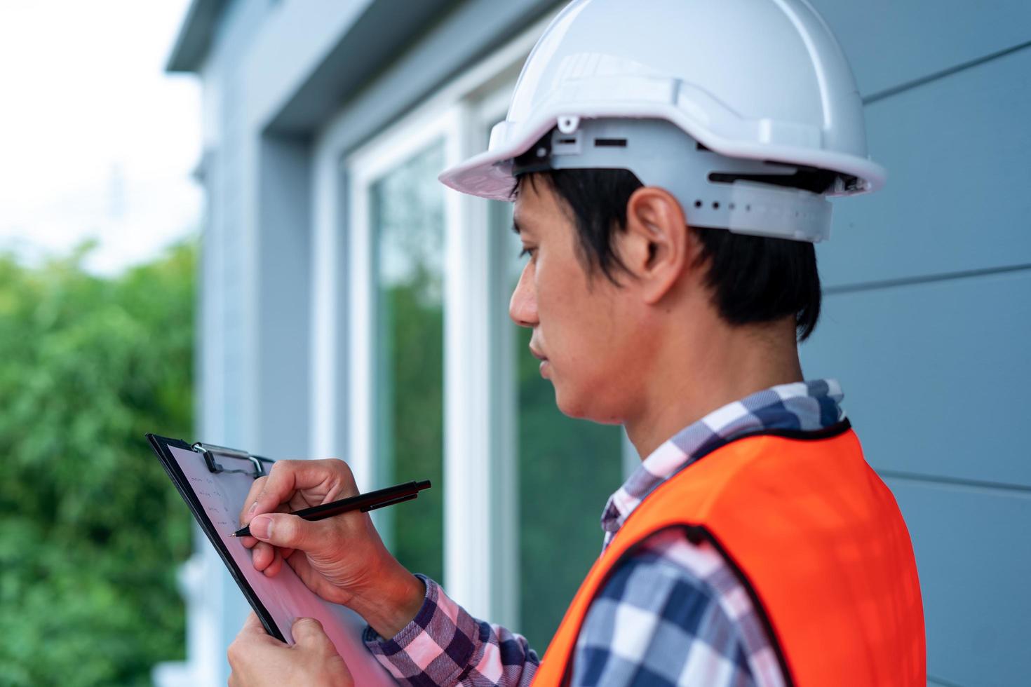 Inspector or engineer is checking and inspecting the building or house by using checklist. Engineers and architects work on building the house before handing it over to the landlord. photo