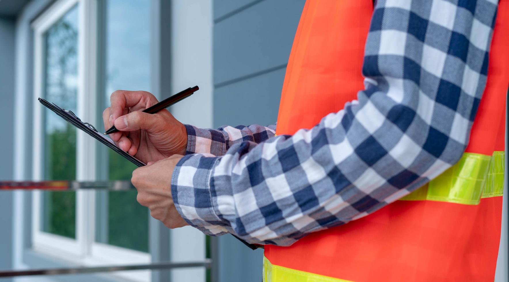 Inspector or engineer is checking and inspecting the building or house by using checklist. Engineers and architects work on building the house before handing it over to the landlord. photo