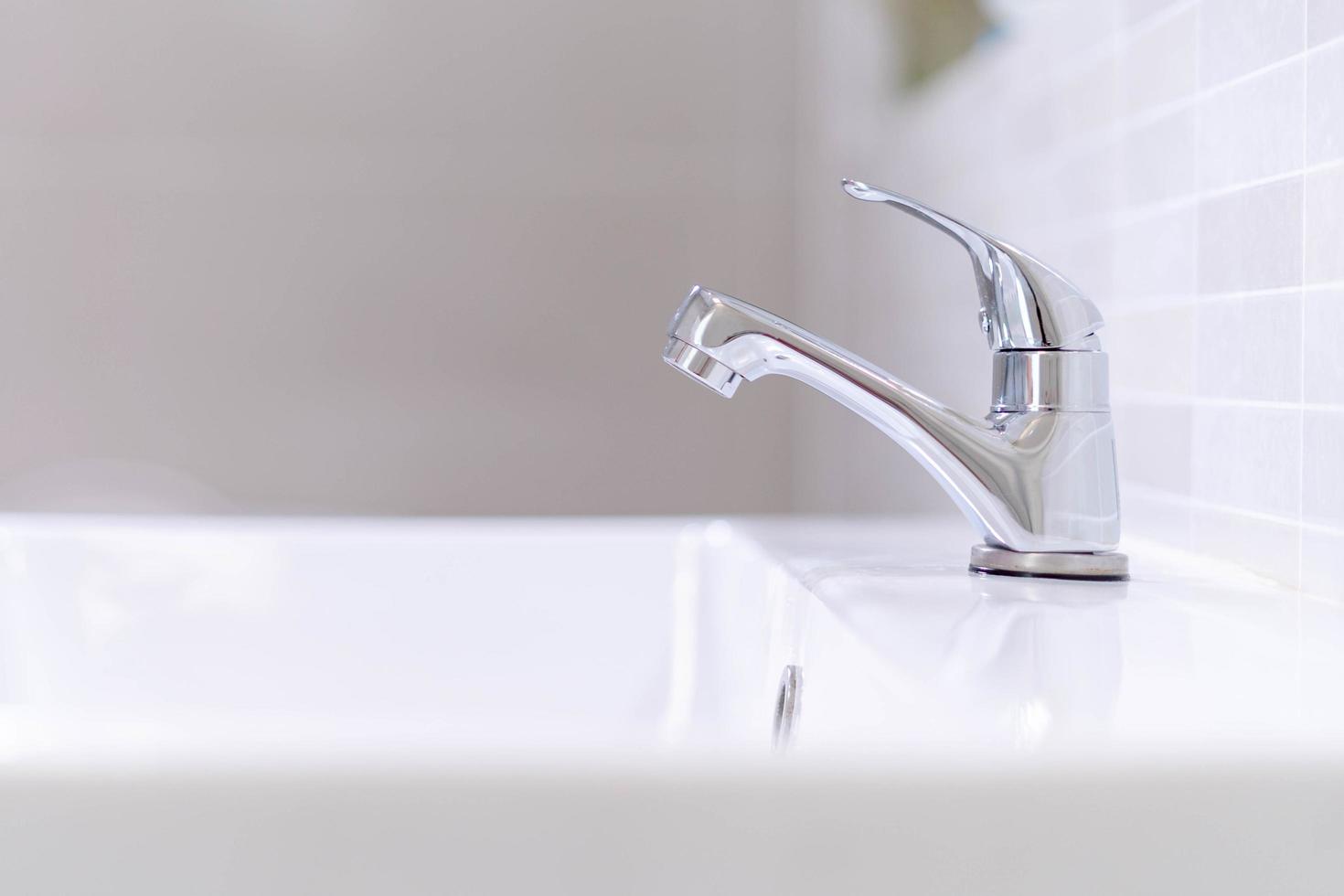The bathroom faucet is turned off to save water energy and protect the environment. water saving concept photo
