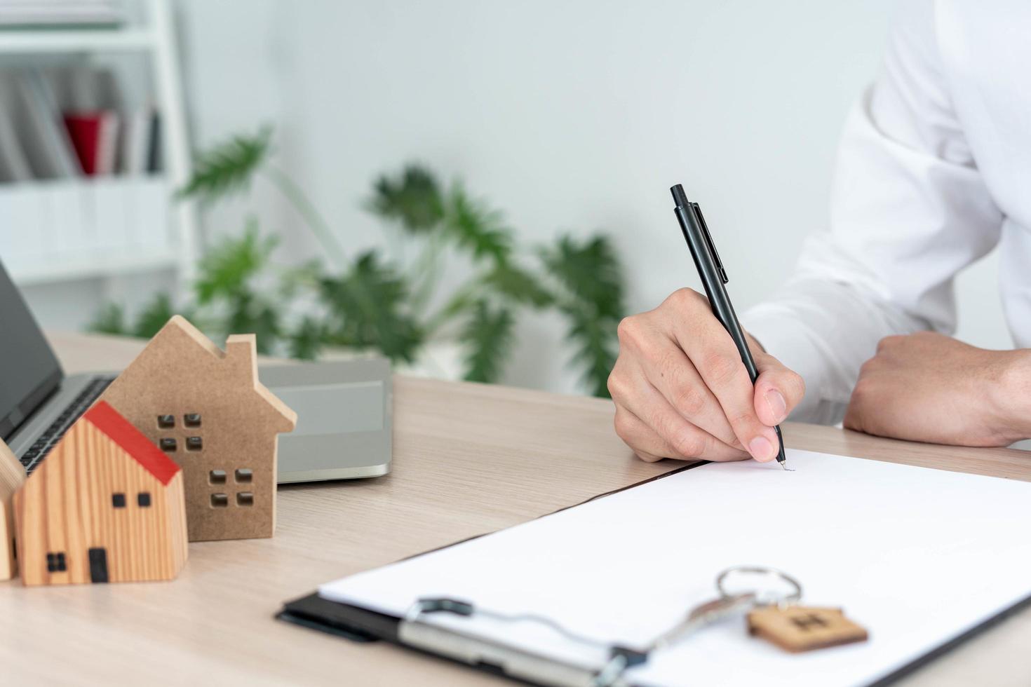 vendiendo casa los agentes de ventas de casas envían las llaves de casa a los clientes. el comerciante cierra el trato con éxito después de que el cliente acepta firmar el contrato. foto