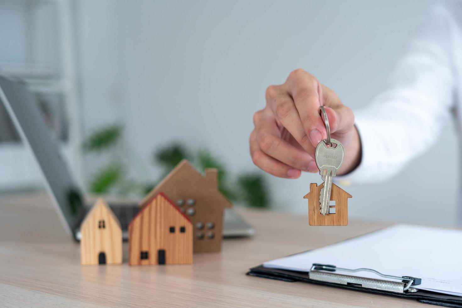 vendiendo casa los agentes de ventas de casas envían las llaves de casa a los clientes. el comerciante cierra el trato con éxito después de que el cliente acepta firmar el contrato. foto