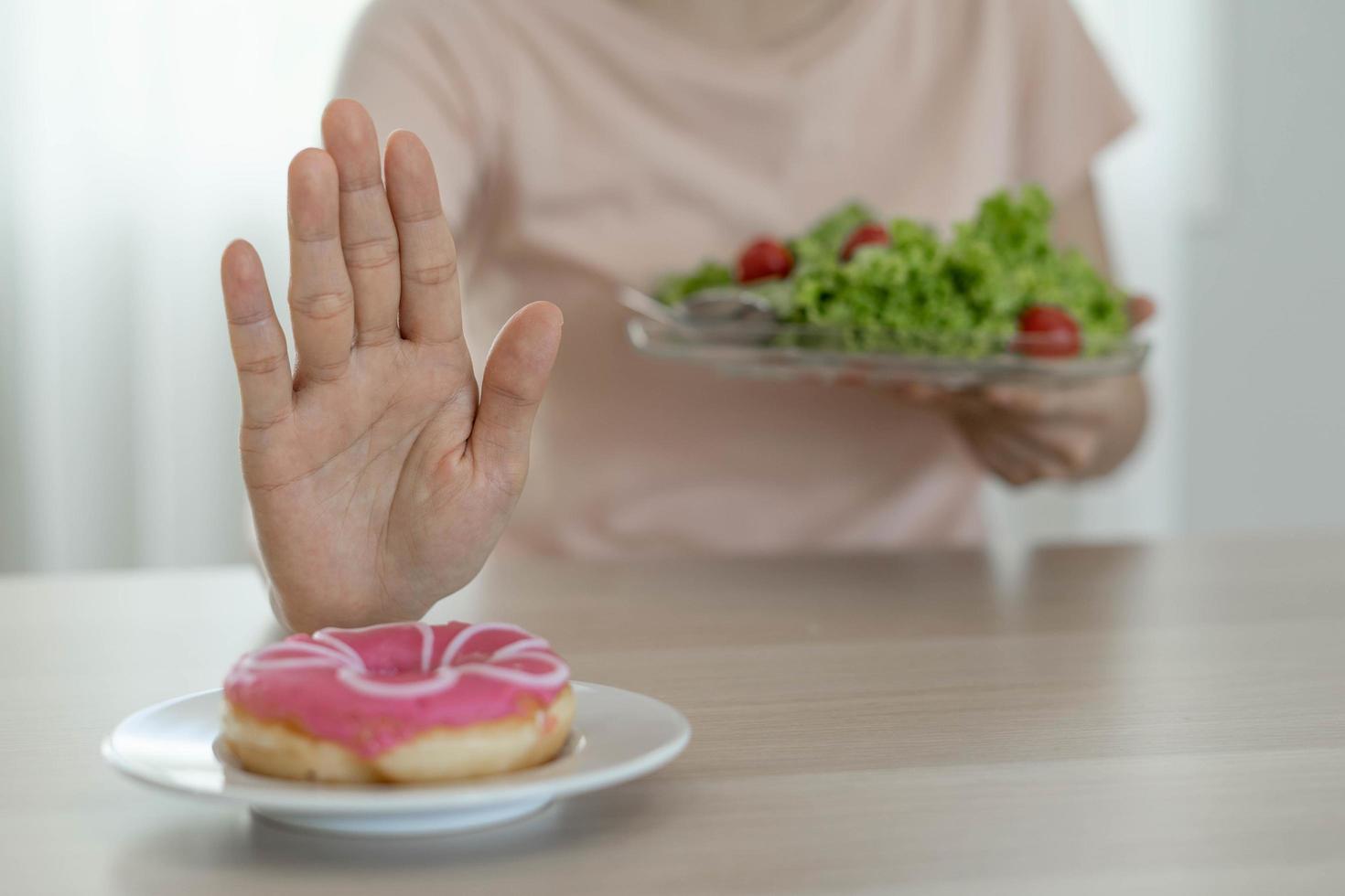 Good health food and diet. Women reject junk food or unhealthy foods such as doughnuts and choose healthy foods such as green apple. photo