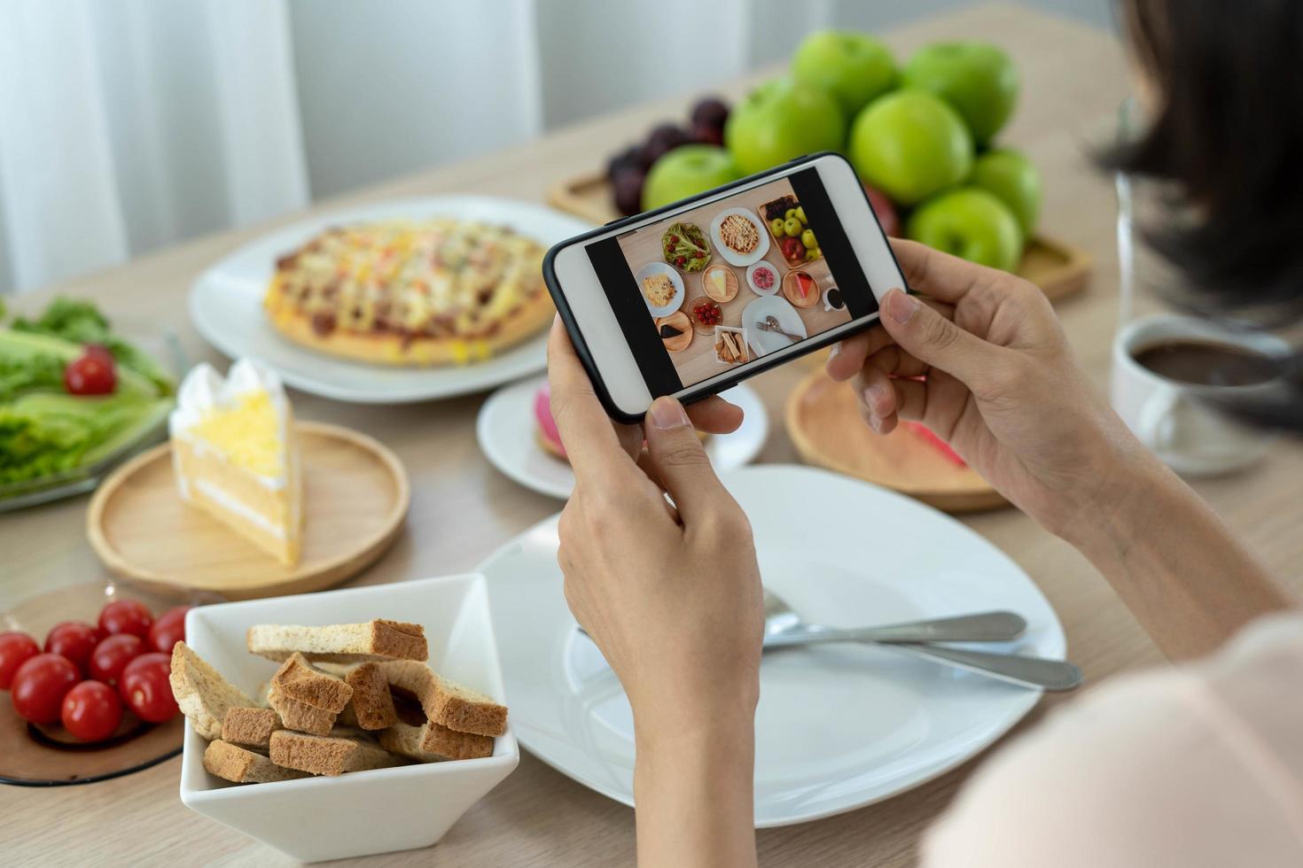 Women use mobile phones to take pictures of food or take live video on social networking applications. Food for dinner looks appetizing. Photography and take picture for review food concepts photo