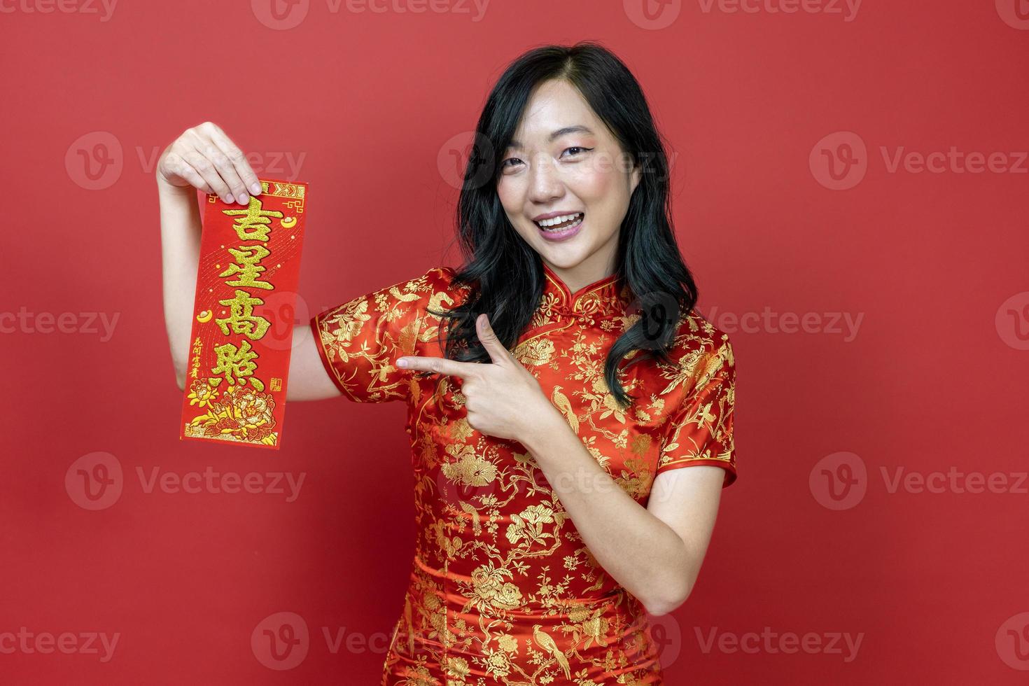 Asian woman holding red fortune blessing Chinese word which means to be blessed by a lucky star isolated on red background for Chinese New Year celebration concept photo