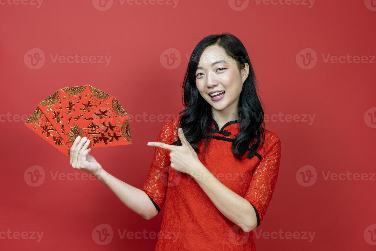 Asian woman holding red money fortune envelope blessing Chinese word which means May you have great luck and great profit isolated on red background for Chinese New Year celebration concept photo